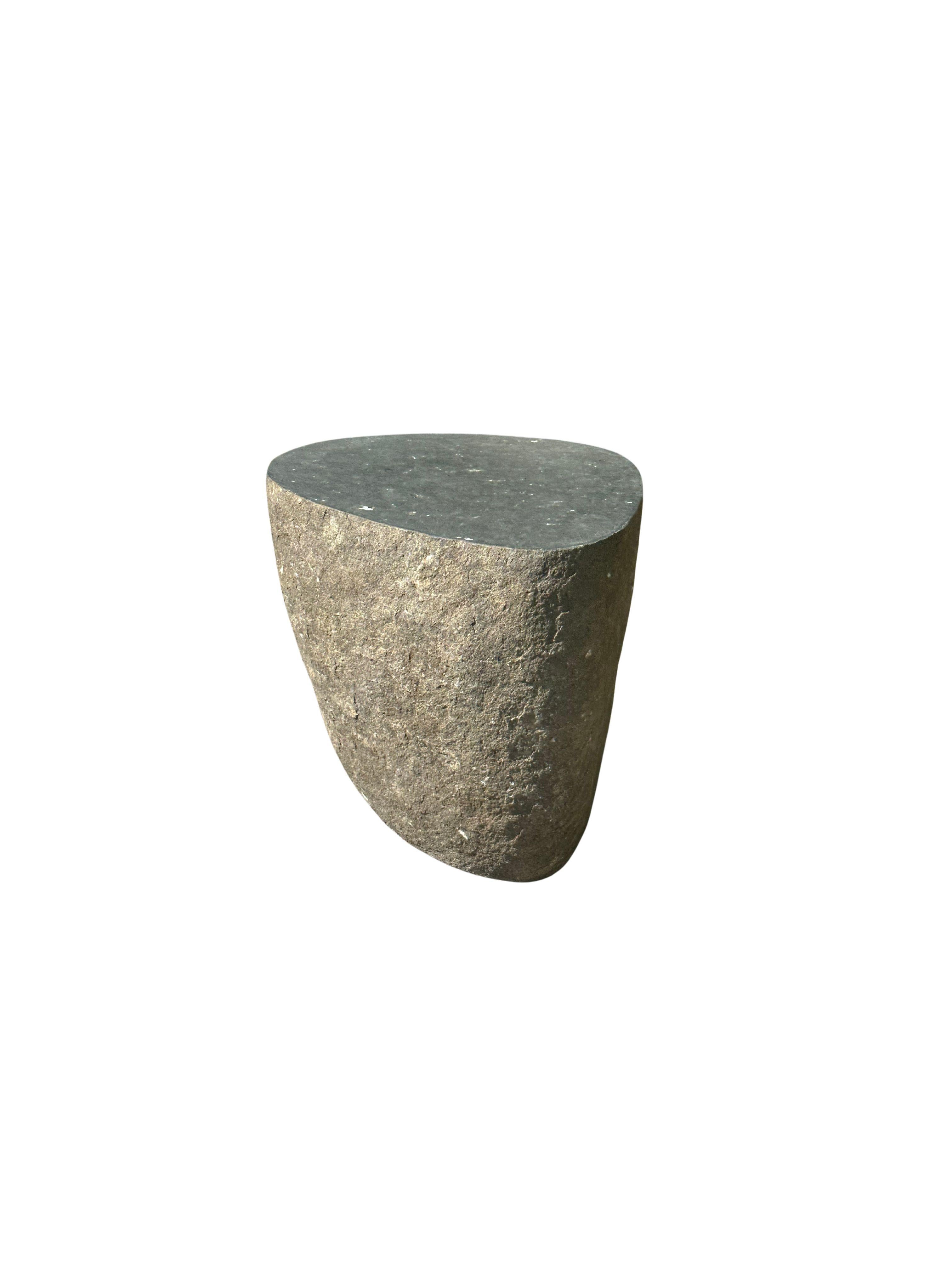Une table d'appoint / piédestal en pierre arrondie incroyablement lourde et solide. Ce bel objet sculptural a été fabriqué à partir d'une pierre massive provenant du lit d'une rivière de l'est de Java. Un objet brut et organique avec de belles