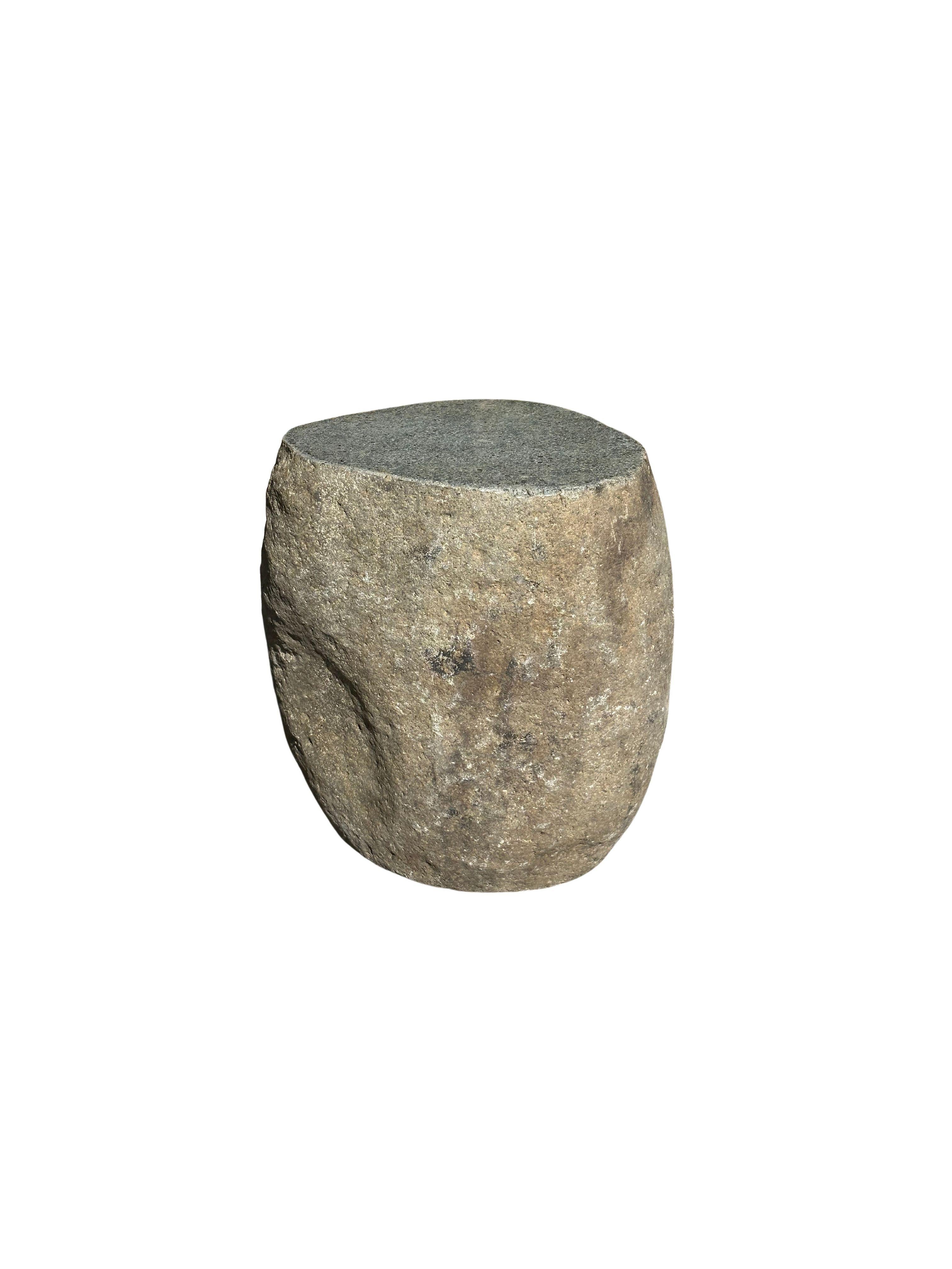 Ein unglaublich schwerer und massiver Beistelltisch / Sockel aus abgerundetem Stein. Dieses schöne skulpturale Objekt wurde aus einem massiven Stein gefertigt, der aus einem Flussbett in Ost-Java stammt. Ein rohes und organisches Objekt mit schönen