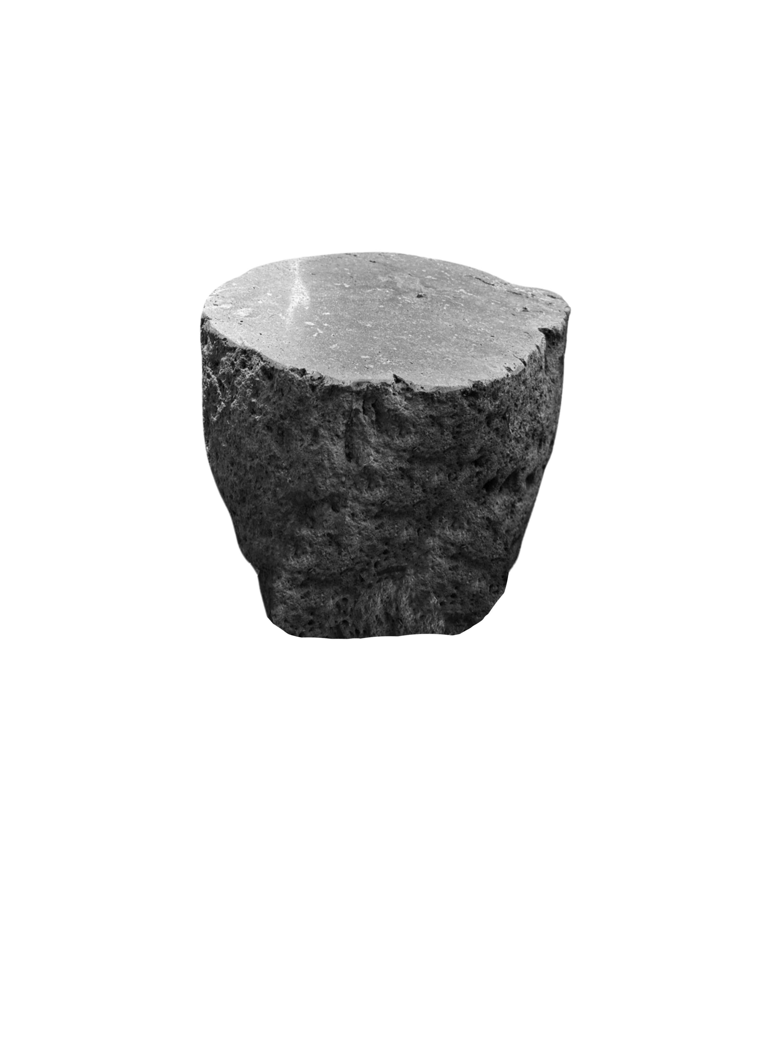 Una mesa auxiliar / pedestal de piedra redondeada increíblemente pesada y sólida. Este precioso objeto escultórico se elaboró a partir de una piedra maciza extraída del lecho de un río de Java Oriental. Un objeto crudo y orgánico con bellas