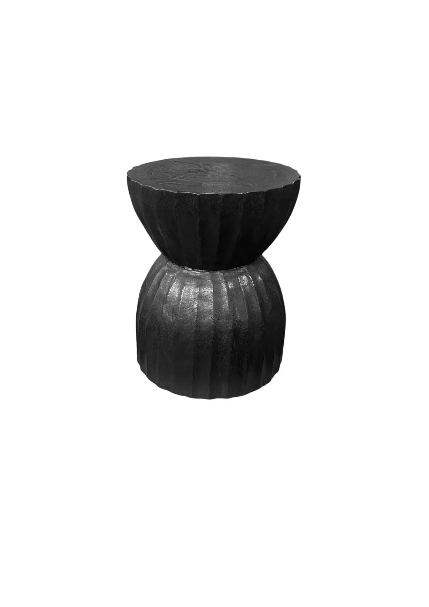 Une table d'appoint ronde merveilleusement sculpturale, en forme de sablier. Ses pigments neutres lui permettent de s'adapter à tous les espaces. Une pièce sculpturale unique et polyvalente qui ne manquera pas de susciter la conversation. Il a été