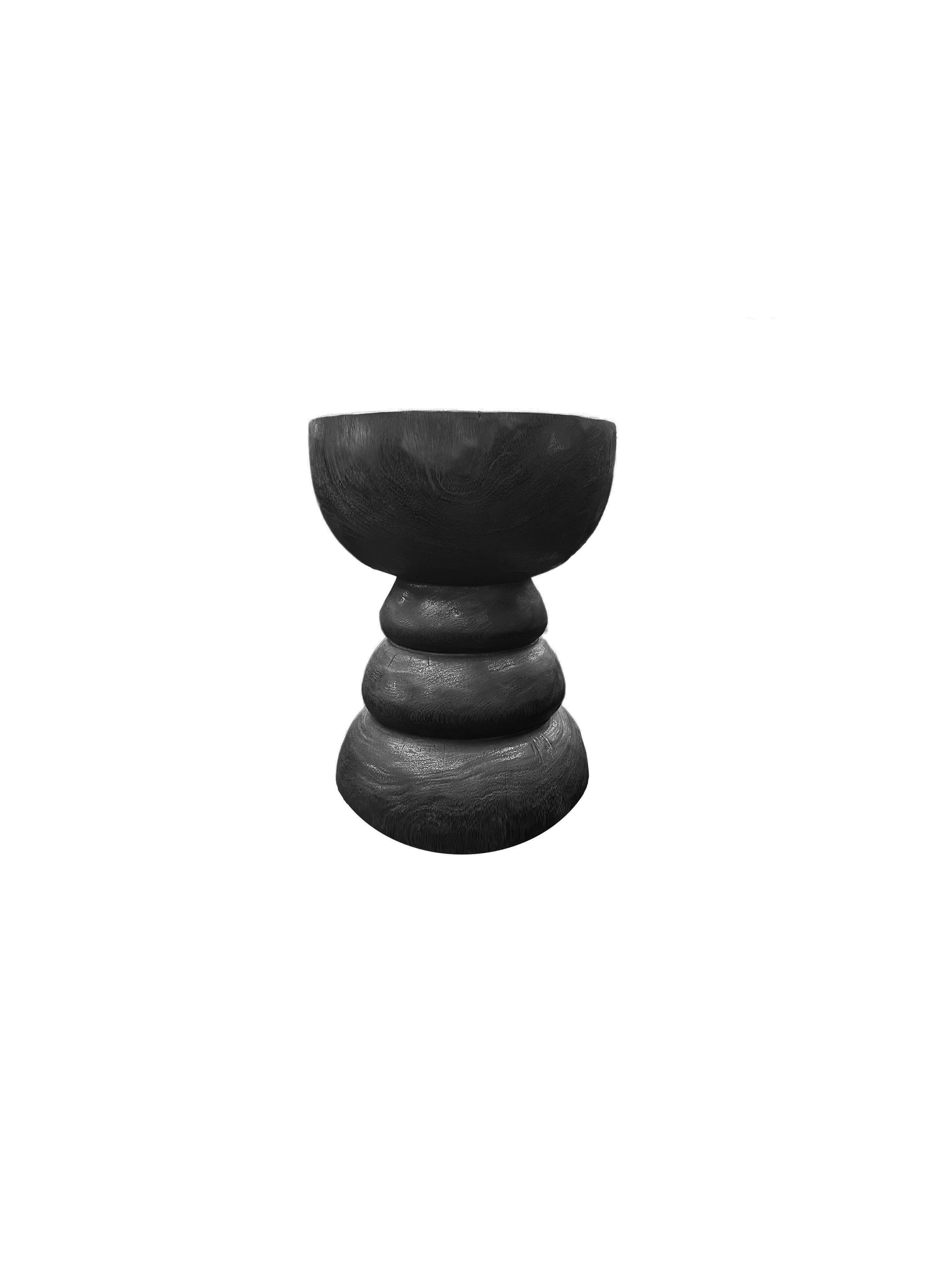 A wonderfully sculptural round side table. Its neutral pigments make it perfect for any space. A uniquely sculptural and versatile piece certain to invoke conversation. It was crafted from a solid block of mango wood and has a smooth texture finish.