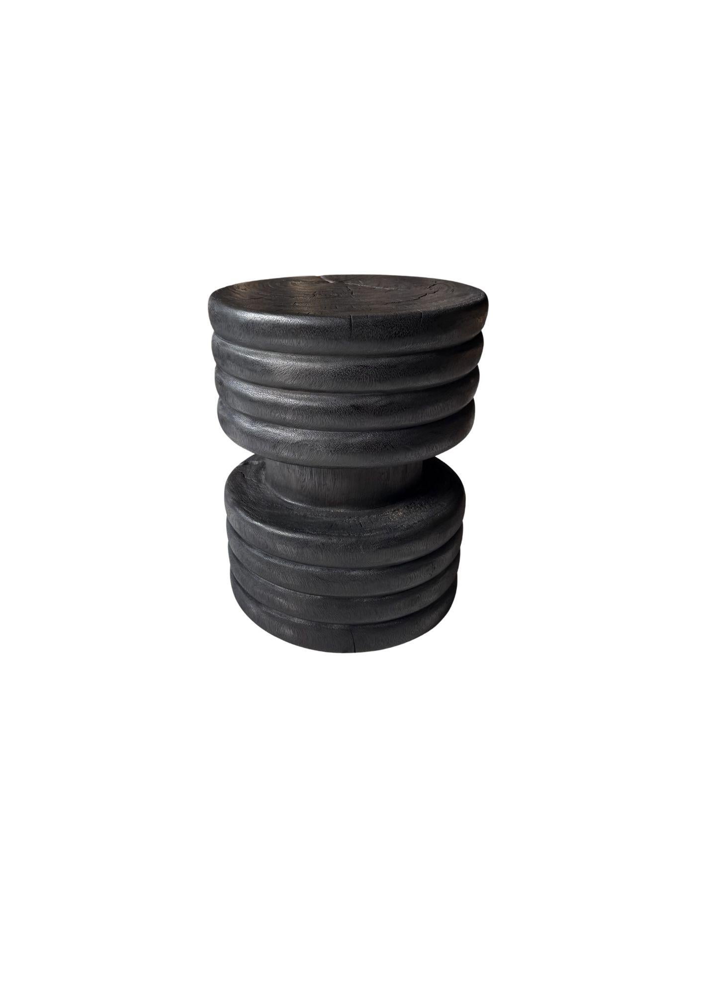 Elevated by artisanal craftsmanship, this suar wood side table is a striking blend of bold character and refined detail. Its cylindrical form is wrapped in elegant, hand-carved ribbed detailing, adding depth and texture to the silhouette. The table