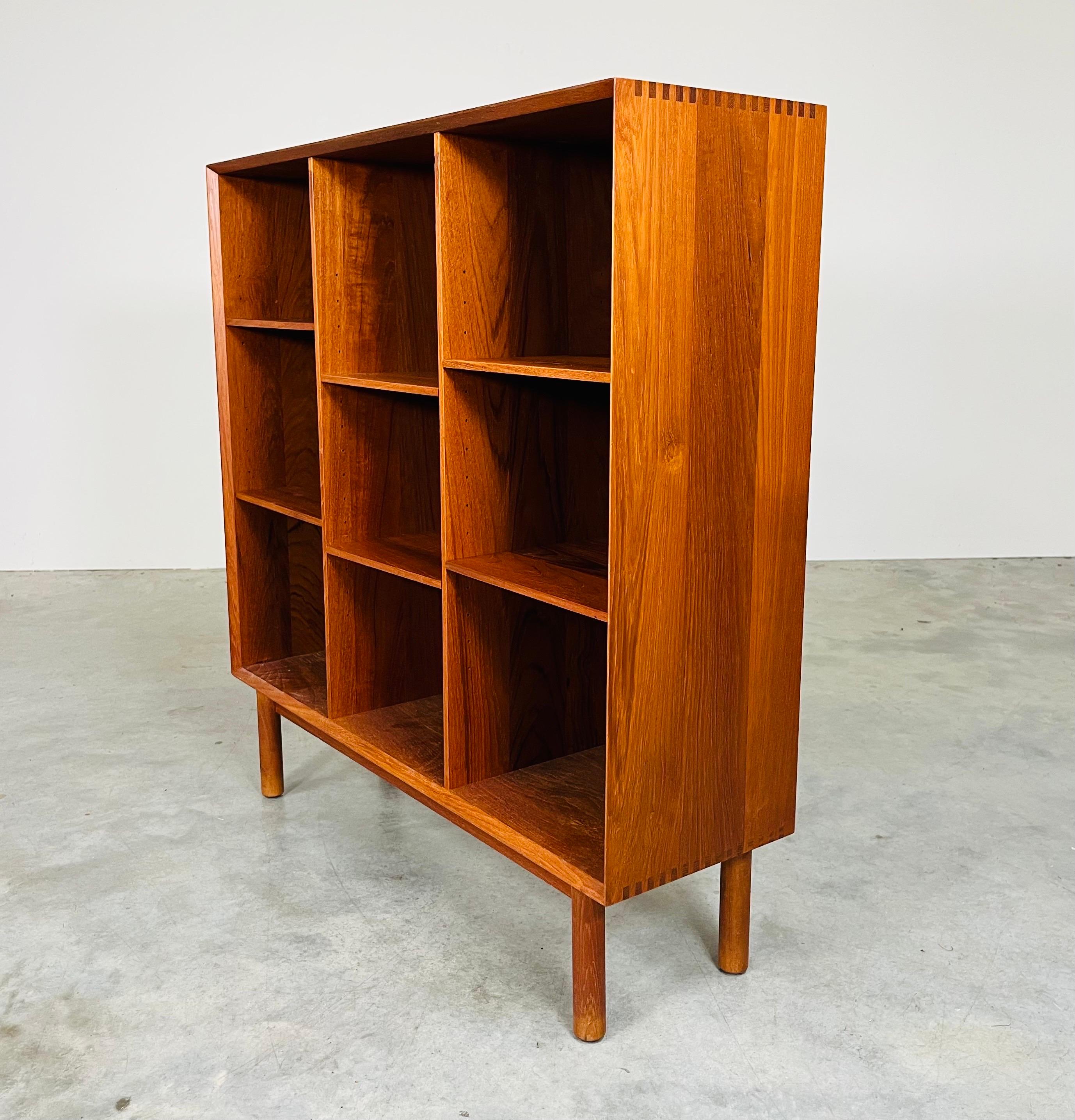 An elegant minimalist teak bookcase having box-joint corners signature in design to Peter Hvidt & Orla Molgaard-Nielsen. Stunning grain throughout with ample shelf space. Shelves are removable should you need more height in a section. 
In excellent