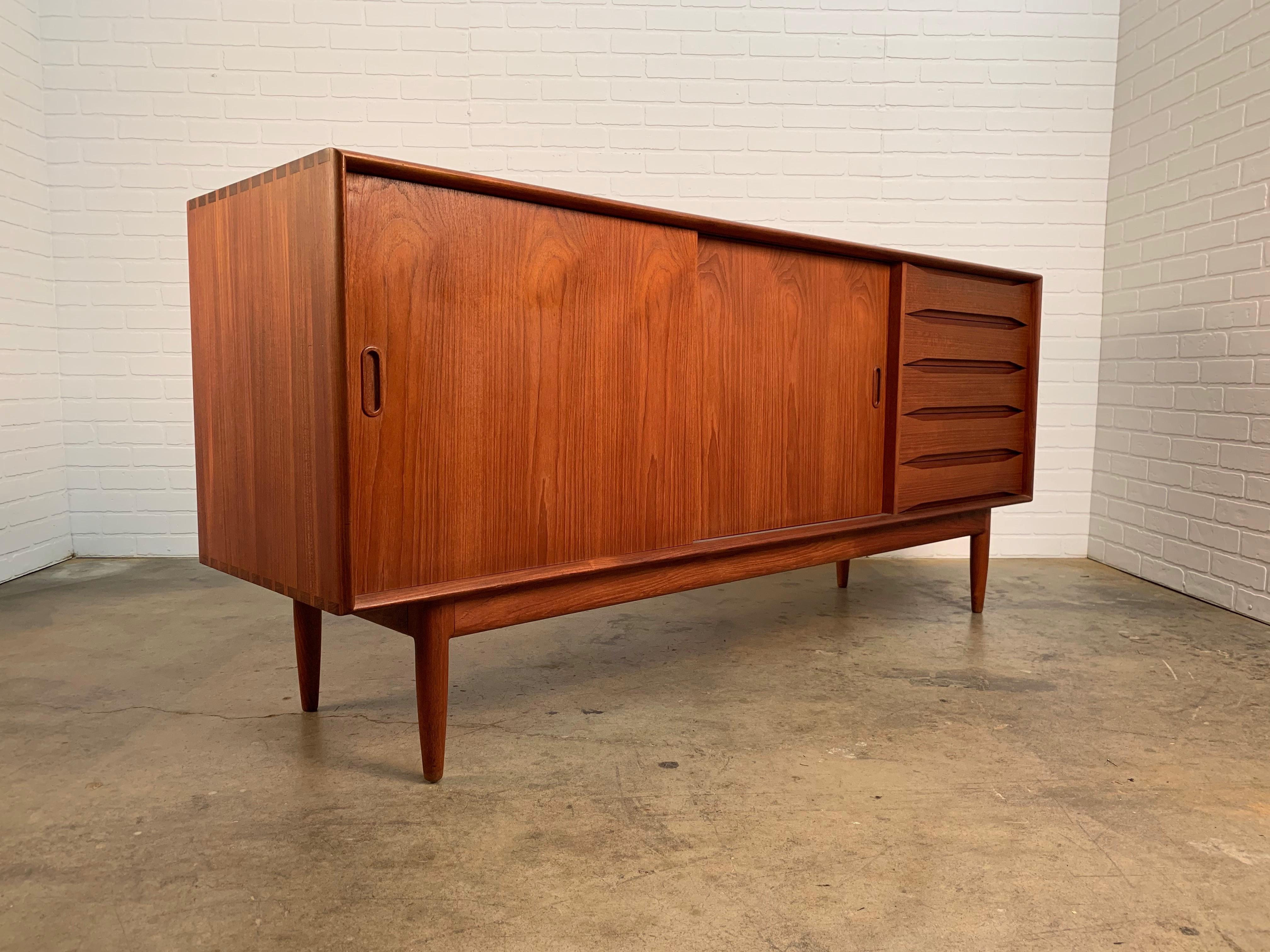 Danish modern solid teak credenza by Johannes Aasbjerg with dovetailed corners on the case and drawers
also two sliding doors that have adjustable shelves inside. The back of the cabinet is finished so it can be floated in a room. Please see
