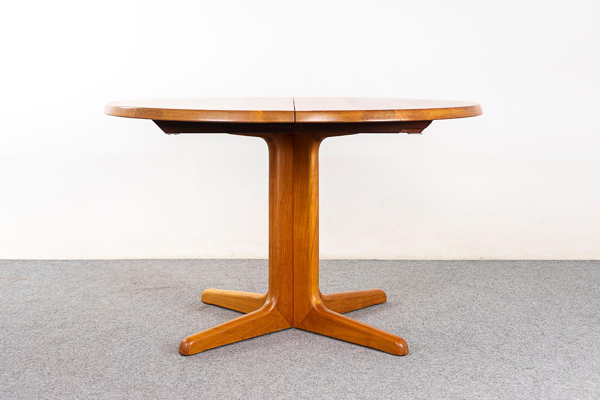 Teak mid-century dining table circa 1970's. Solid teak construction with a beveled edge. Pedestal base and leaf enables you to seat 6-8 guests! Perfect for those dining rooms where every inch counts. 

Unrestored item with option to purchase in