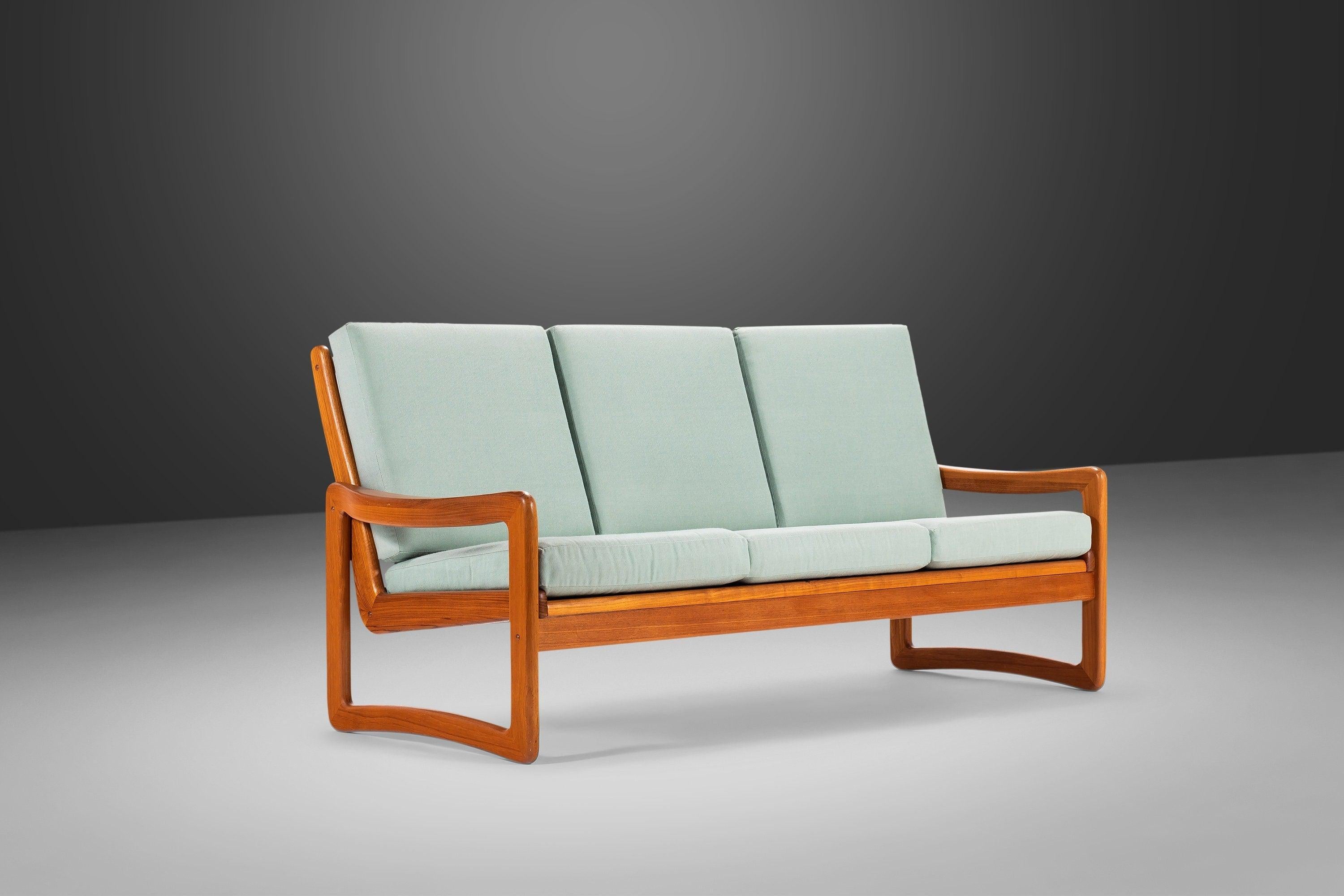 Exceptional vintage solid teak three-seater sofa by Sun Cabinet. The Danish modern design features an elegantly contoured U-shaped leg that joins seamlessly with the arms. The ladder rung backside is particularly striking, elevating this lounge