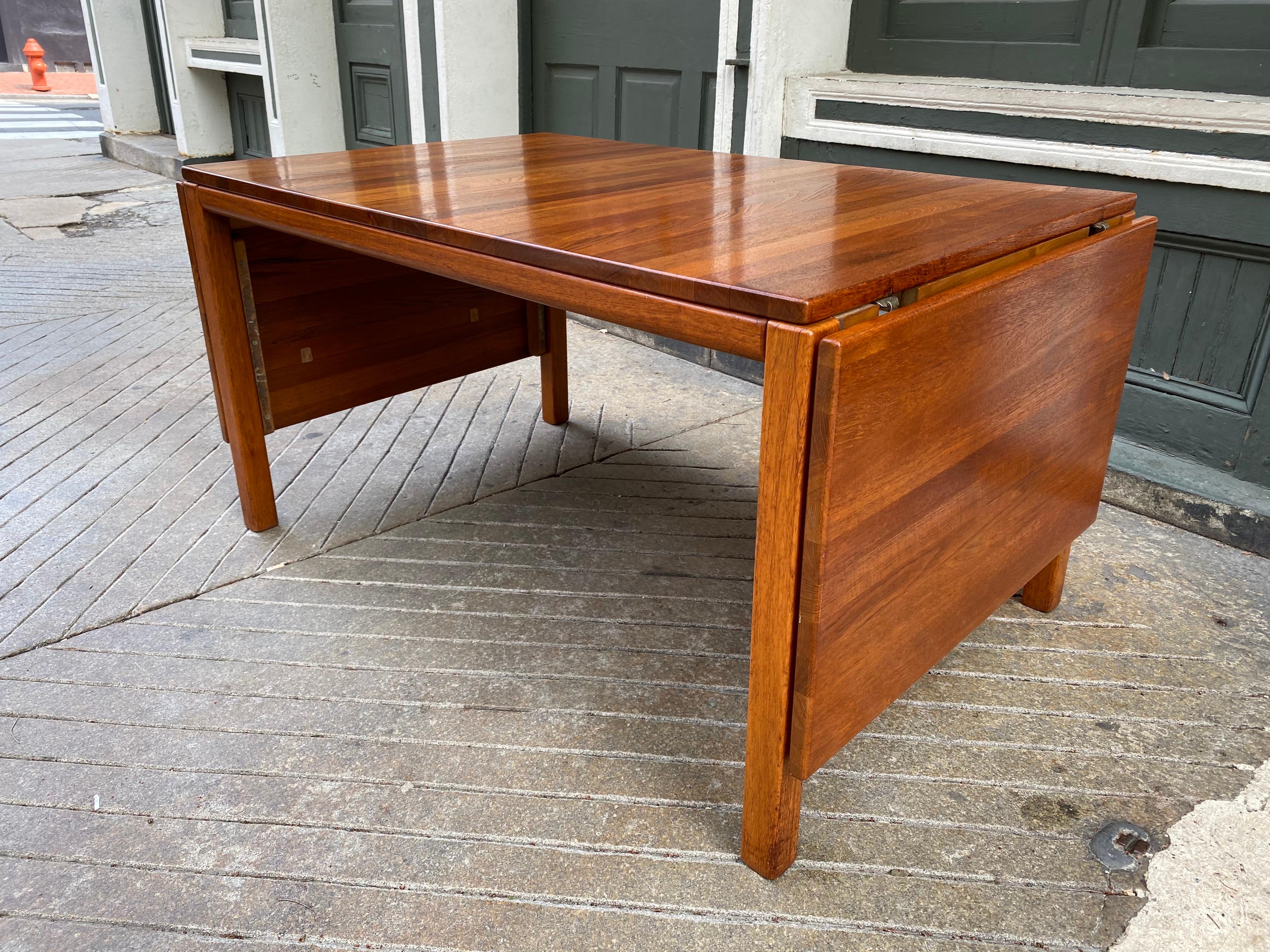 Solid teak dining table with two removable drop leaves. Perfect to use as a desk/work surface or dining! Nice size when both leaves up, measuring 90