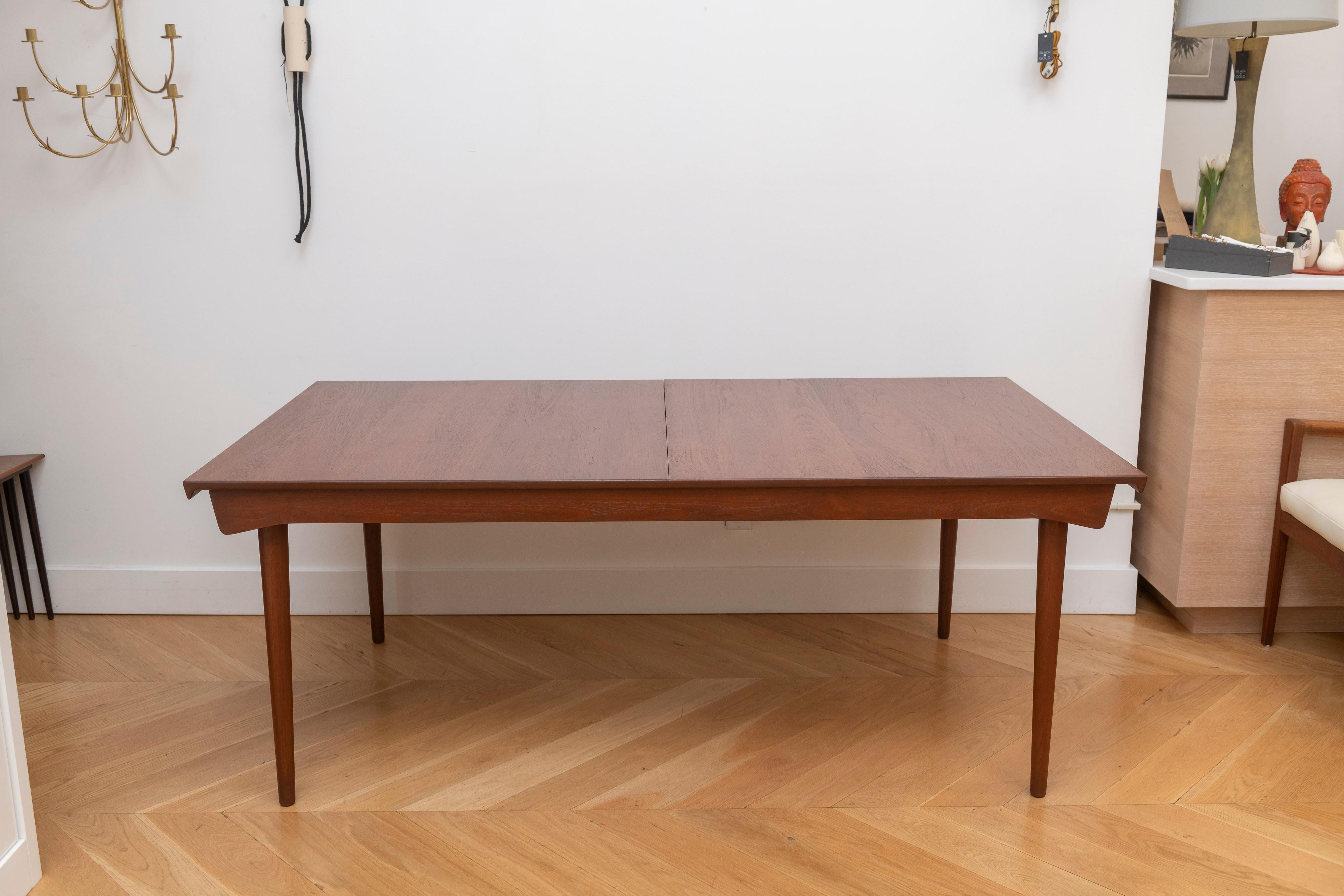 An exceptional all original example from Finn Juhl for France and Sons. This table is in solid teak, no veneers, and is extremely well built. The dining table includes two leaves that conveniently store underneath when not in use, and when inserted
