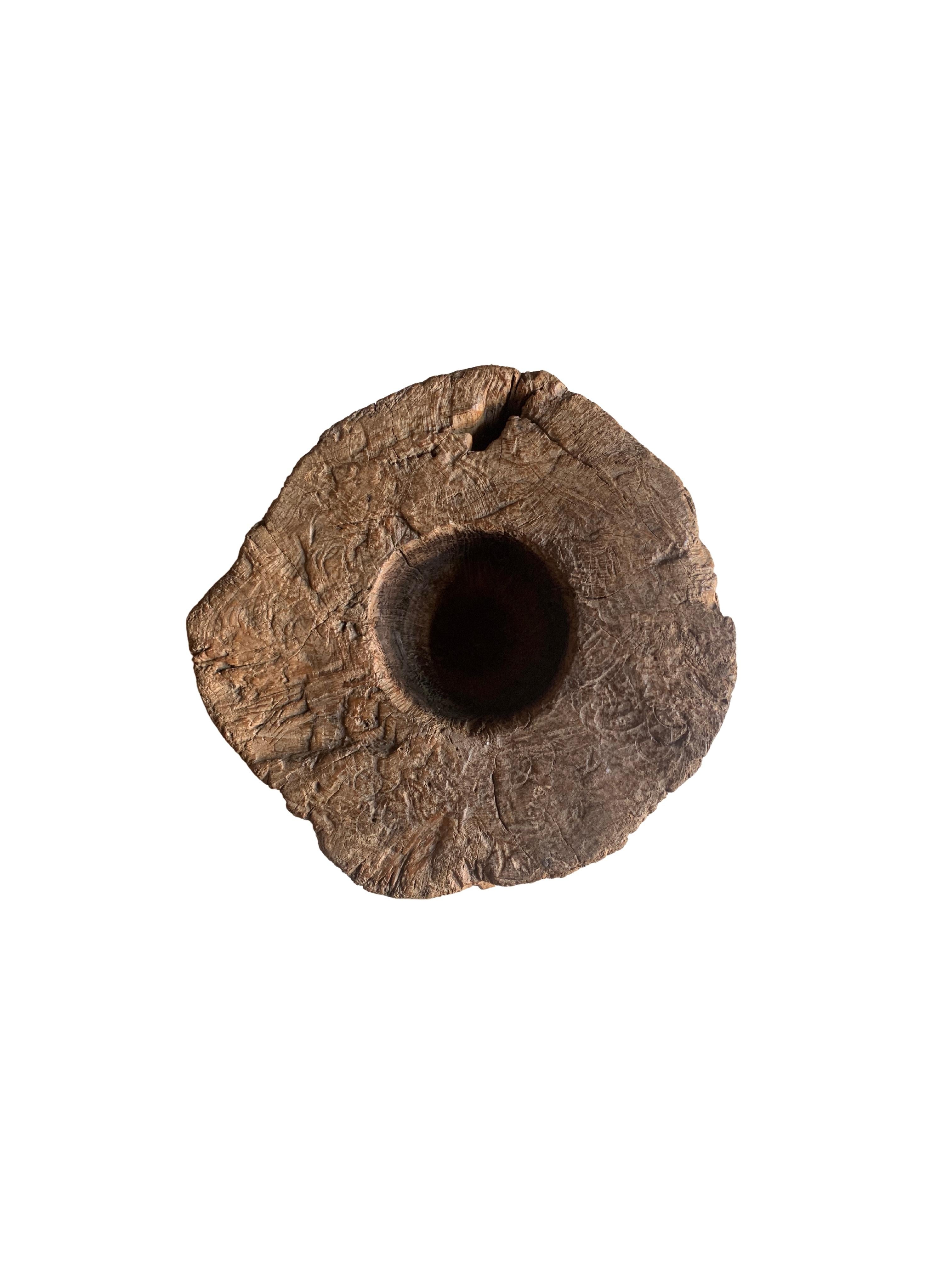 A vintage mortar bowl soured from rural Java & crafted from a solid teak wood slab. A raw and organic object with beautiful wood textures and imperfections. A versatile decorative object to bring warmth and life to any space, despite its once