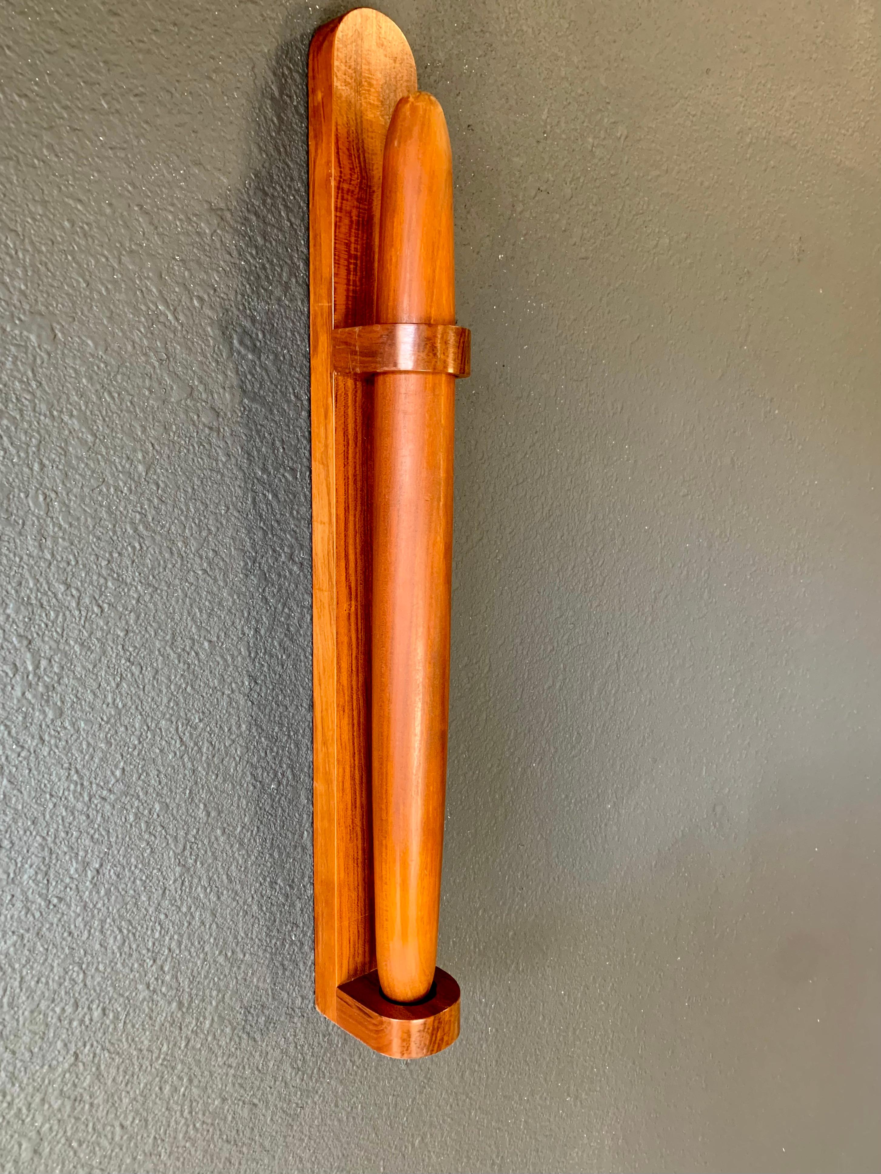 Hand crafted out of solid Teak this Rolling pin has the weight to be a good food preparer as well as a equalizer in any disagreement. mounted on a wall stand and ready for action.