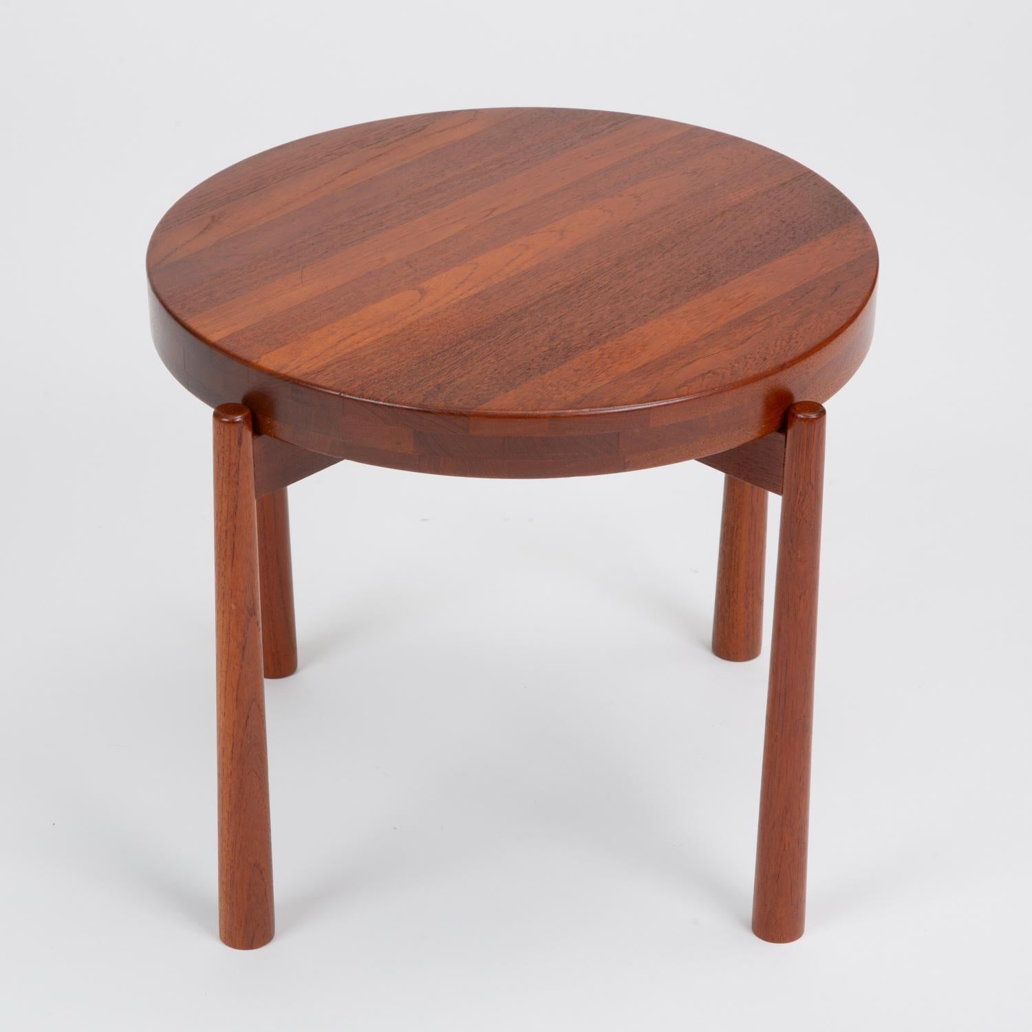 A clever “flip top” tray table design by DUX of Sweden. A stand on four flared legs holds a solid teak wooden tray, fully finished on both sides for reversible use — flat for use as a traditional table, and concave for a bowl or tray. The concave