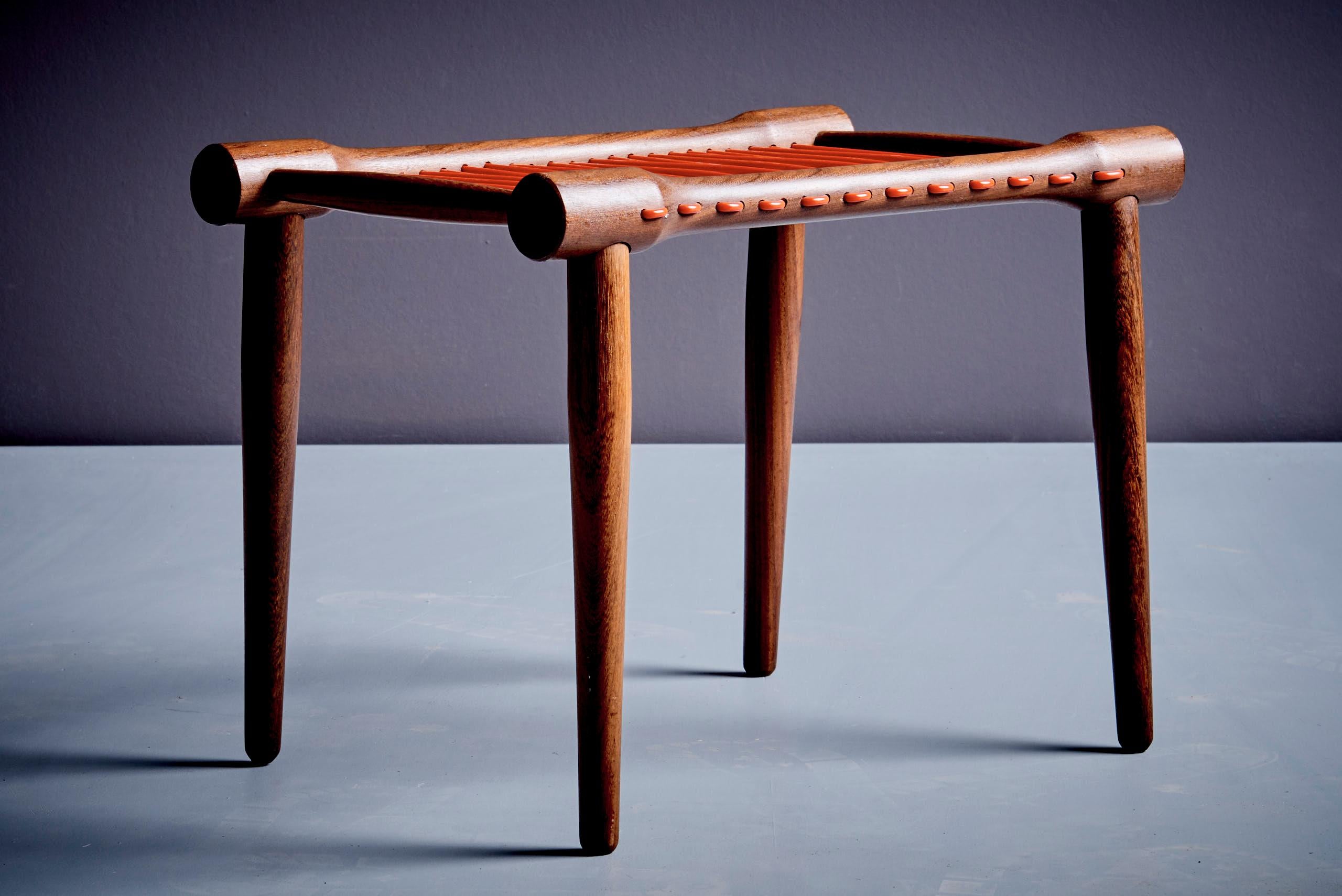 Beautifully crafted Danish modern teak stool, likely a bespoke or limited-run piece from a small Danish workshop in the 1960s. Made of solid teak with tapered round legs and cylindrical rails—classic Scandinavian construction. The seat is woven in