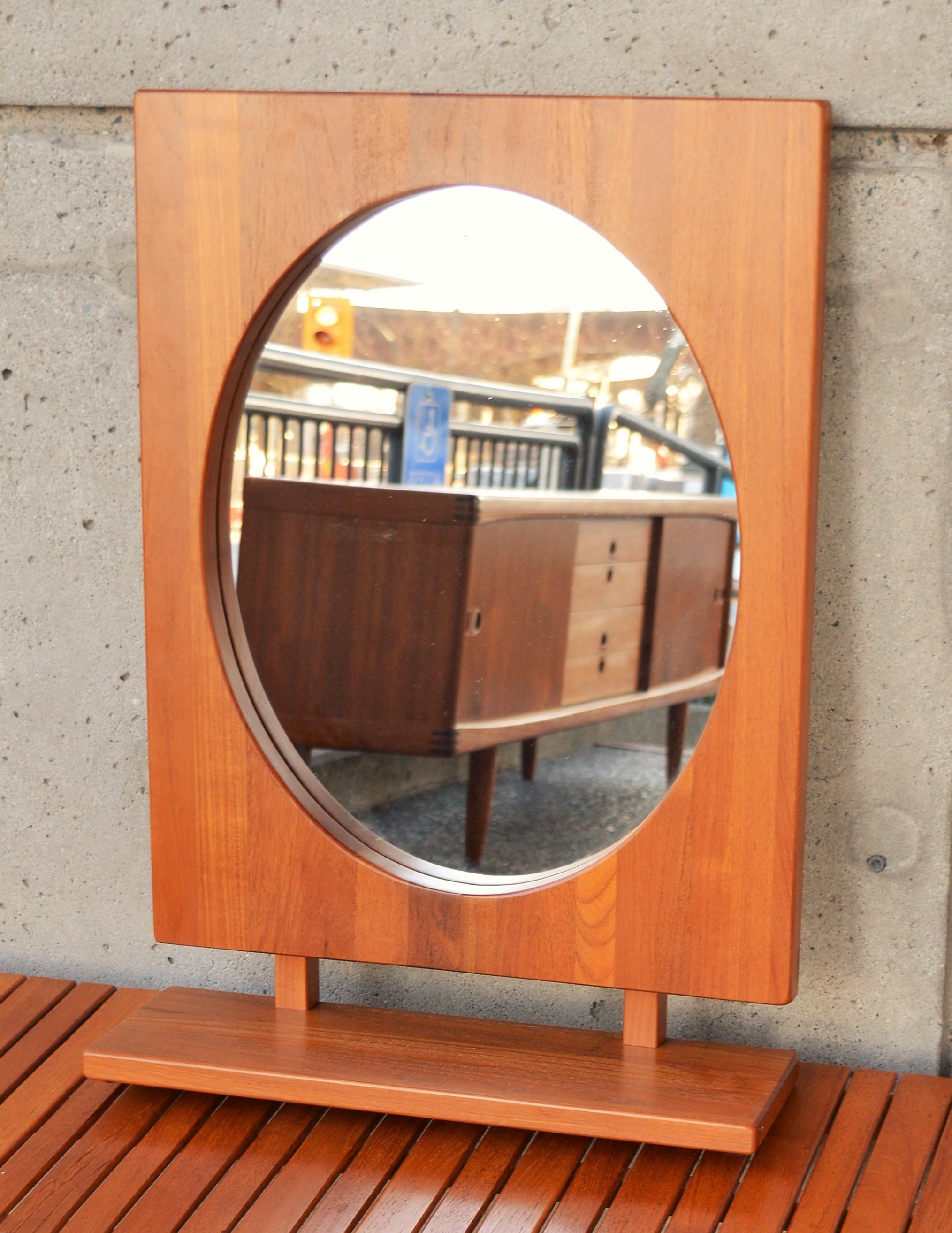 This exquisite table or wall mirror is made entirely of solid teak, and features an oval mirror. Designed by Pedersen & Hansen, Denmark, in the 1960s. In excellent condition and freshly oiled, with no scratches or nicks or damage to the mirror.