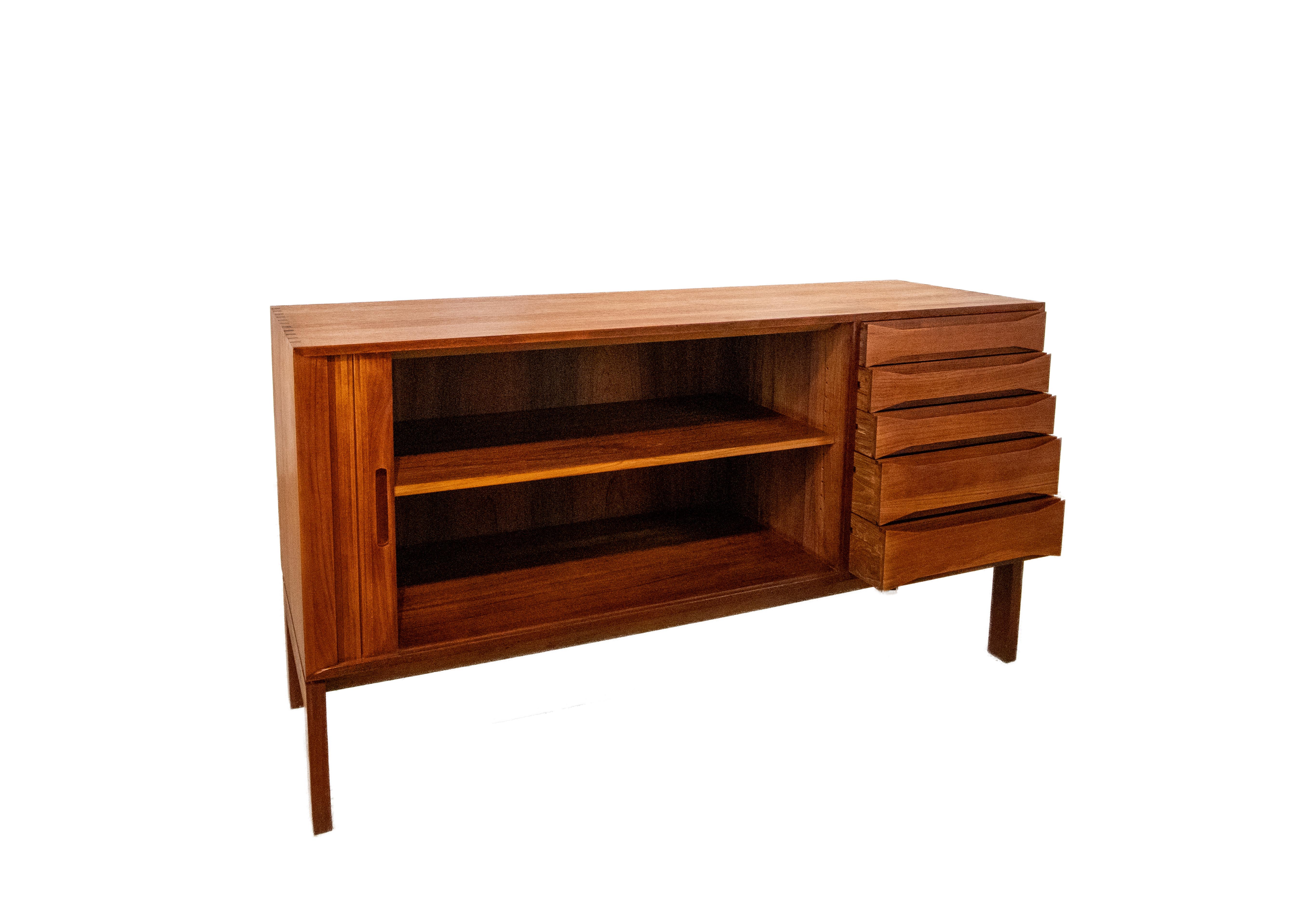 A wonderfully crafted solid teak credenza designed by Johannes Aasbjerg. A great combination of details including a thick solid teak slat sliding tambour door. The solid teak box is joined with dovetail joints similar to cabinets from Peter Hvidt