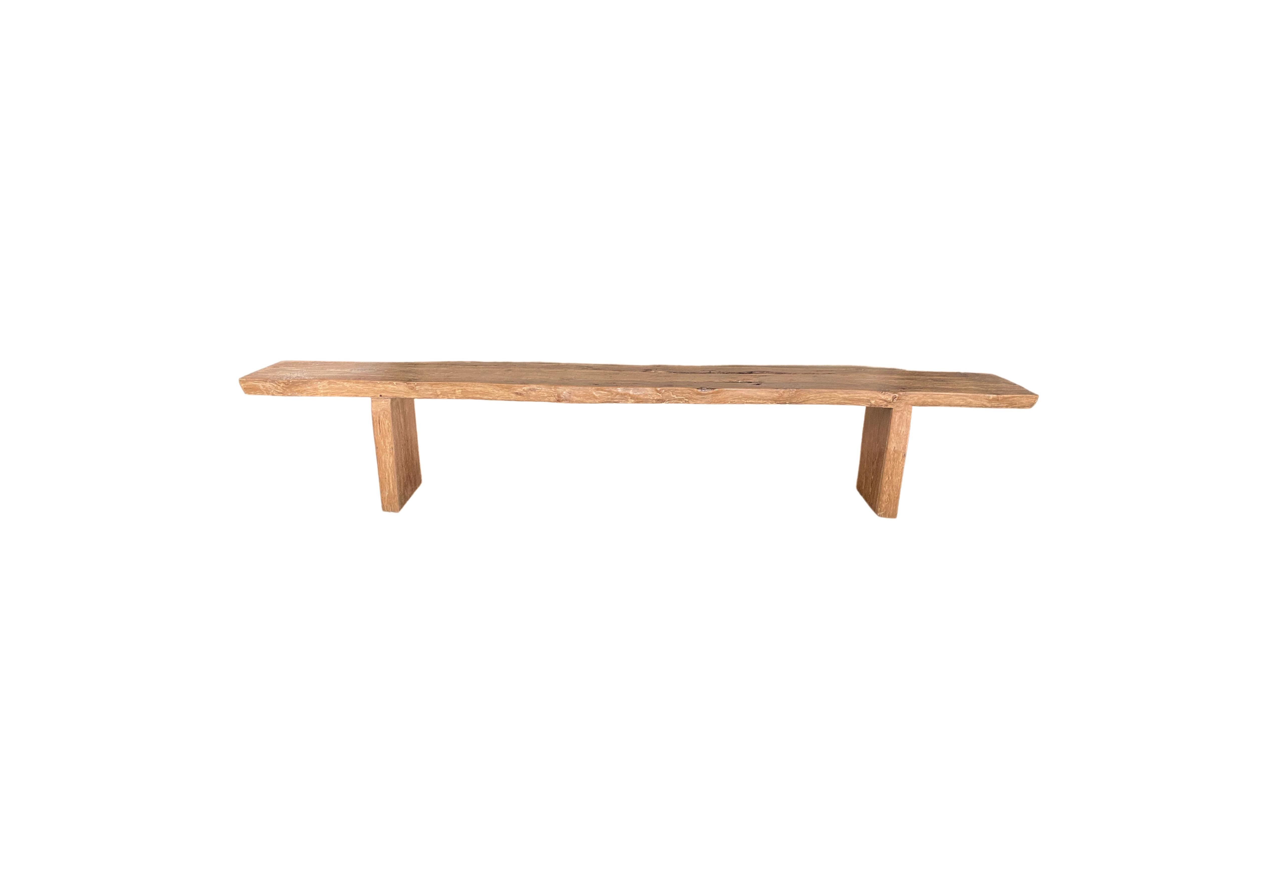 This solid teak wood bench originates from the Island of Madura, off the coast of Northeastern Java. It features a wonderful organic form with a mix of wood textures and shades. The seat was carved from a single block of teak wood and has been given