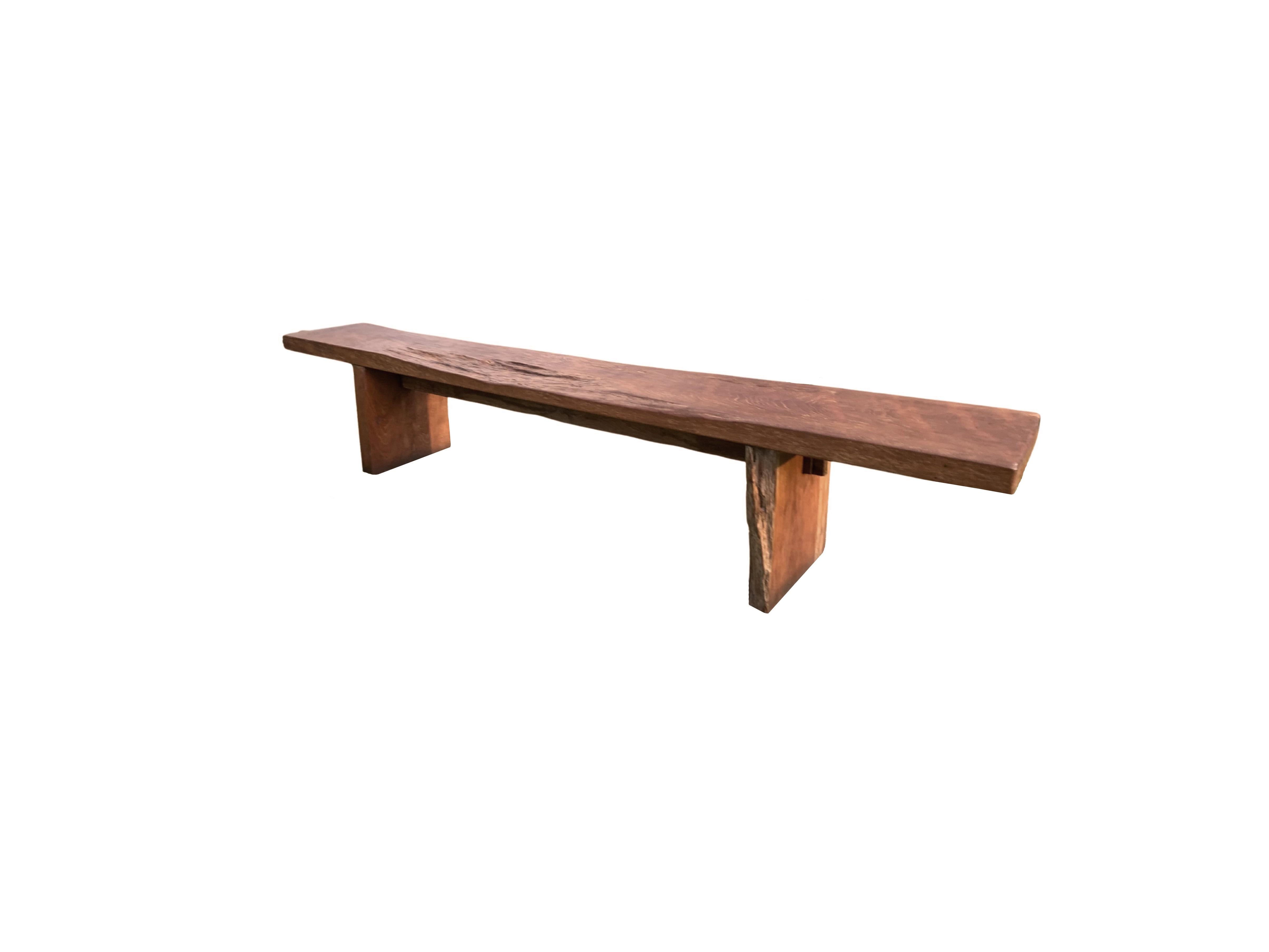 This solid teak wood bench originates from the Island of Madura, off the coast of Northeastern Java. It features a wonderful organic form with a mix of wood textures and shades. The seat was carved from a single block of teak wood and has been given
