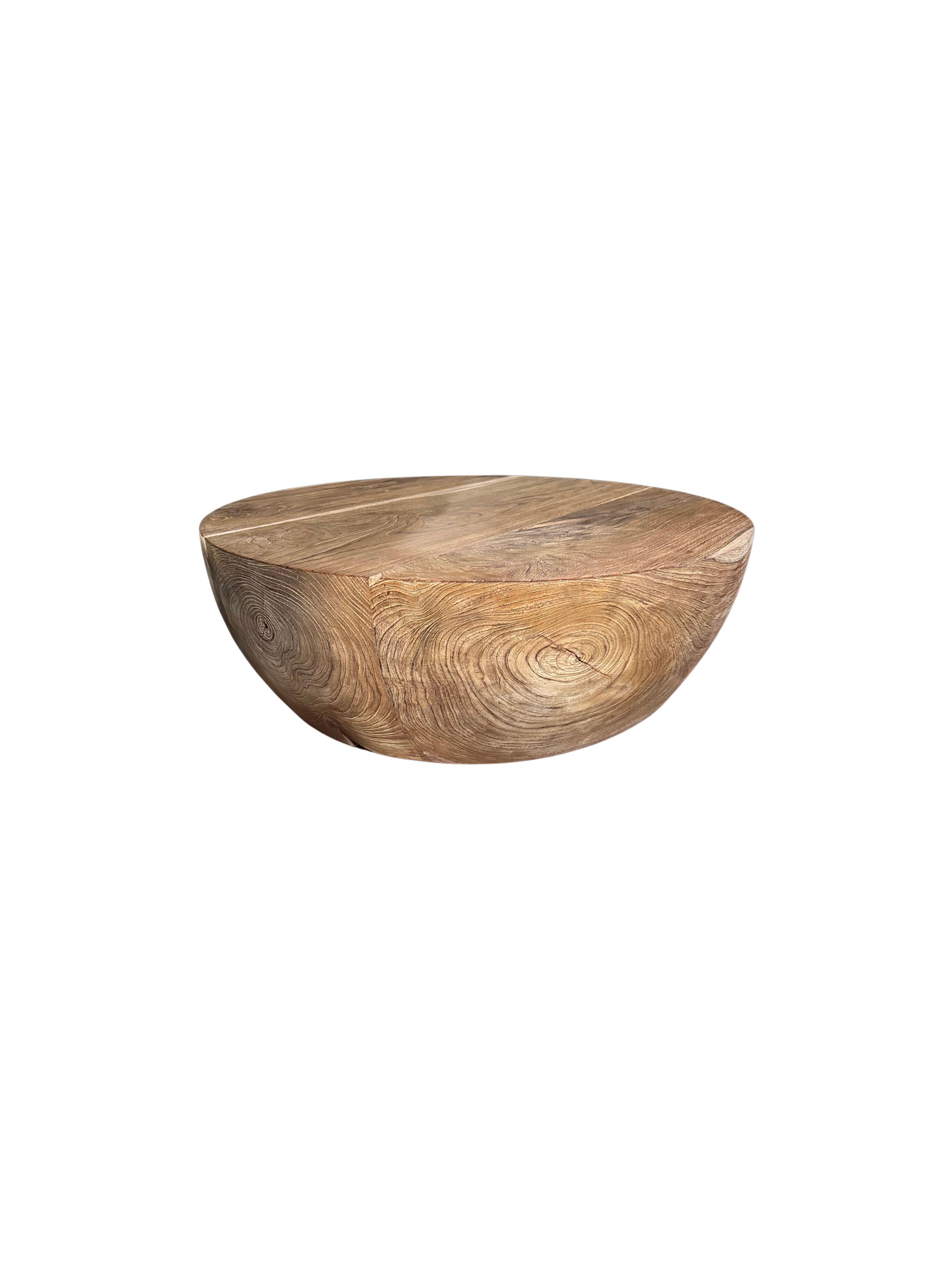 This solid teak wood table features wonderful wood textures and shades. Its neutral tones make it the perfect addition to bring warmth to any space. A sculptural and versatile piece. This table was crafted from joining several larger slabs of teak
