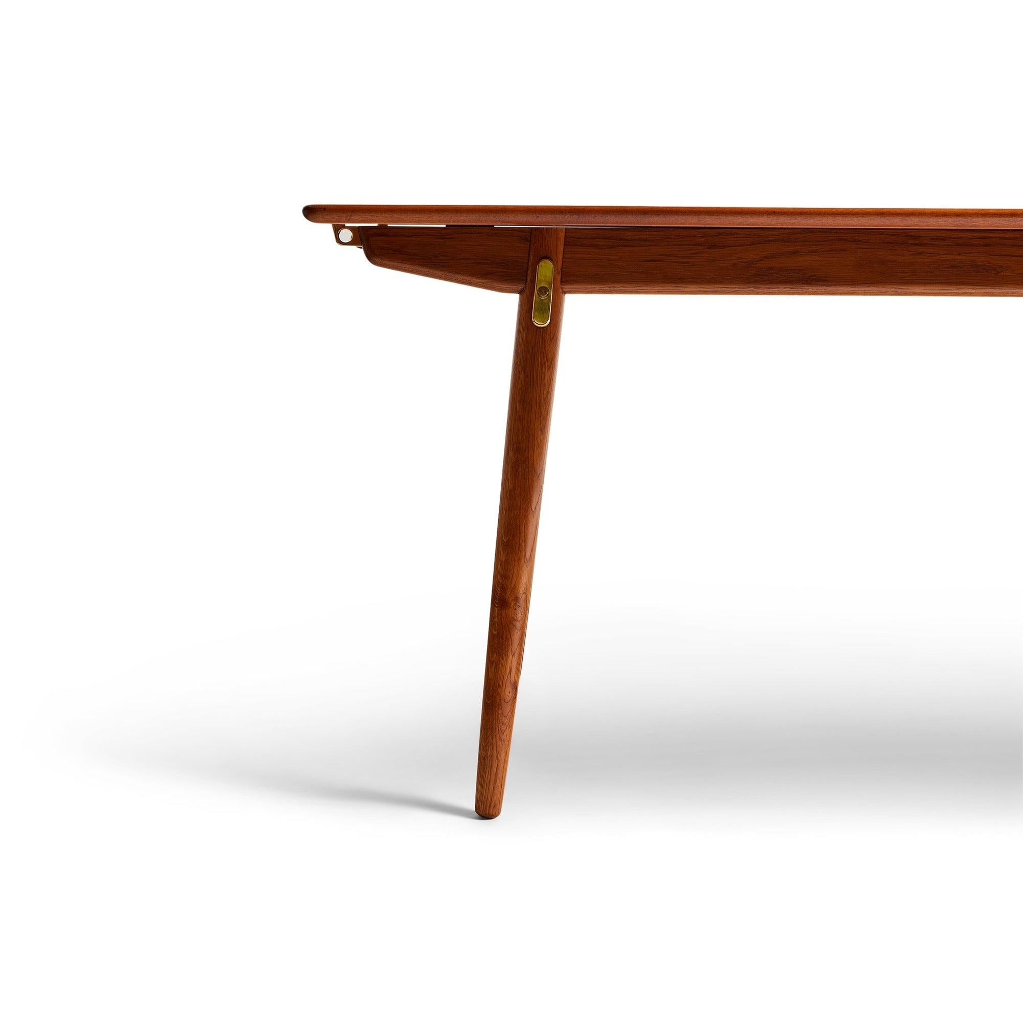 A rectangular dining table with a teak top concealing steel and brass pullouts and an innovative hidden leaf storage on a fumed oak base with splayed, tapered dowel legs. (Two extensions are 20.25