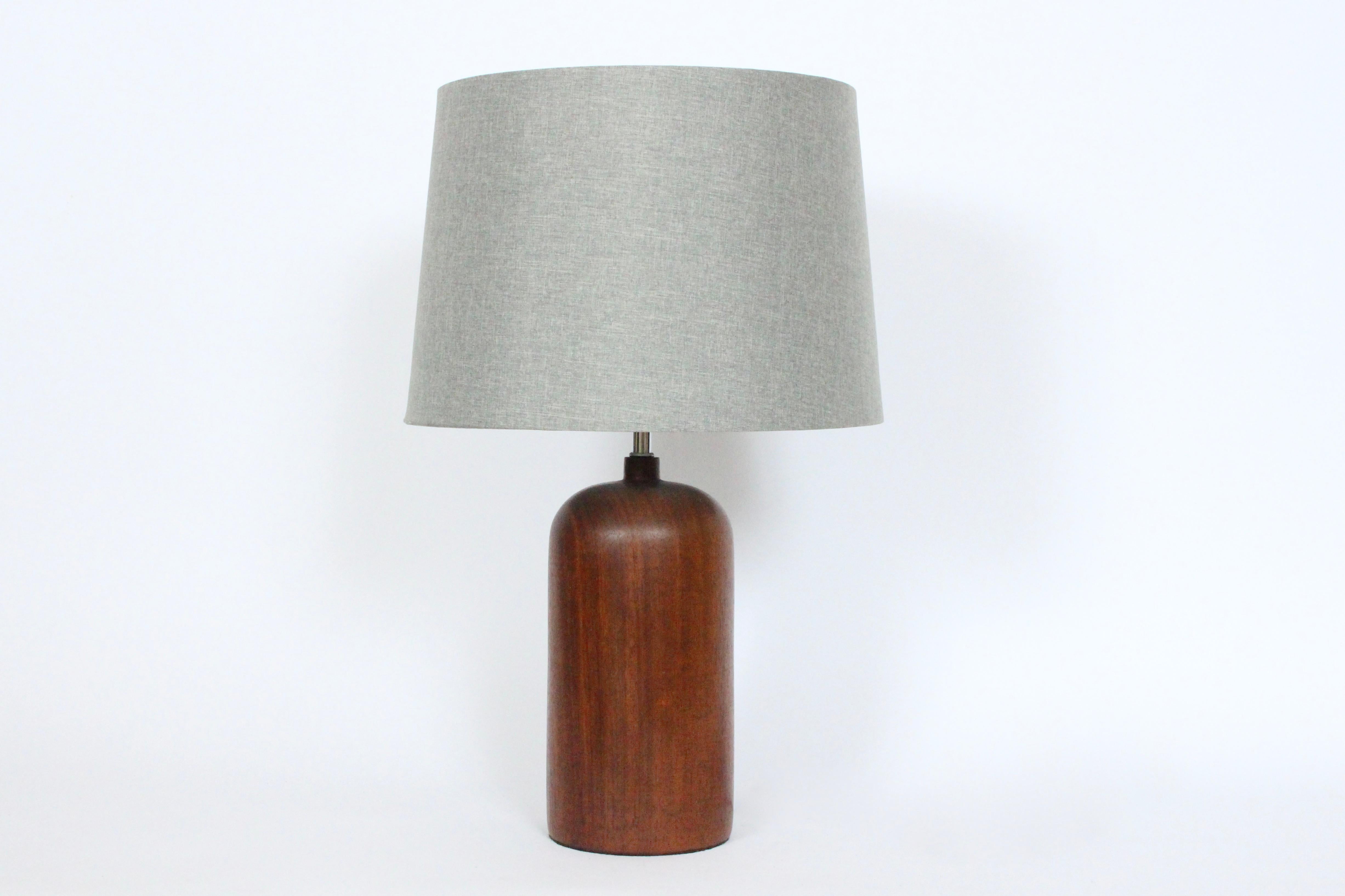 Danish Mid Century Modern turned solid Teak Table Lamp, Circa 1960. Featuring a rounded smooth beautifully grained Dark Teak column form with Chrome neck. 17 H to top of socket. 12H to top of Teak. Shade shown for display and not for sale (10.5H x