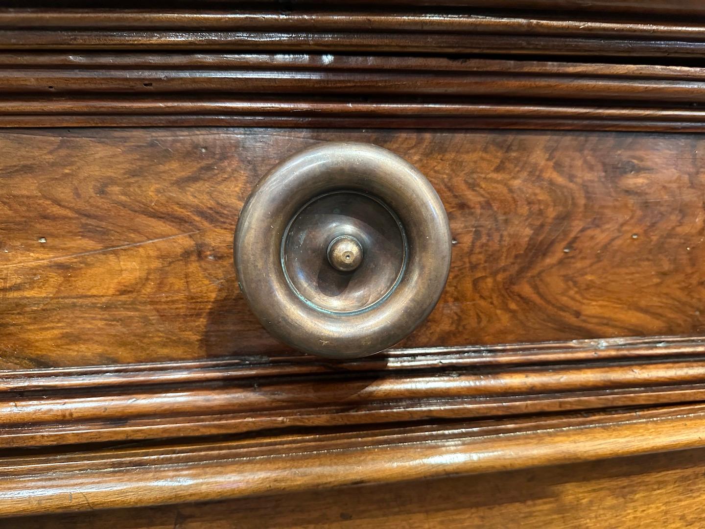 Large, Mid-19th century, clipped corner, paneled buffet with a large single drawer over two-doors below. The whole on a raised base.  Antique gilded bronze knobs are replacement knobs, not original to piece.