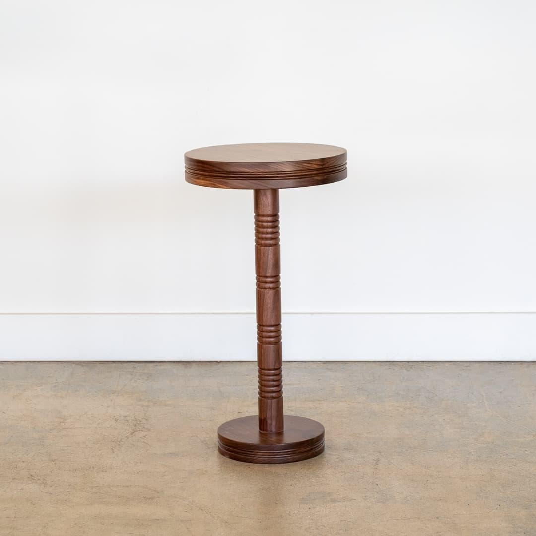 Newly made solid walnut drink table with carved ribbed detailing on stem. Circular top and circular base. Made in Los Angeles. Multiple quantity available.