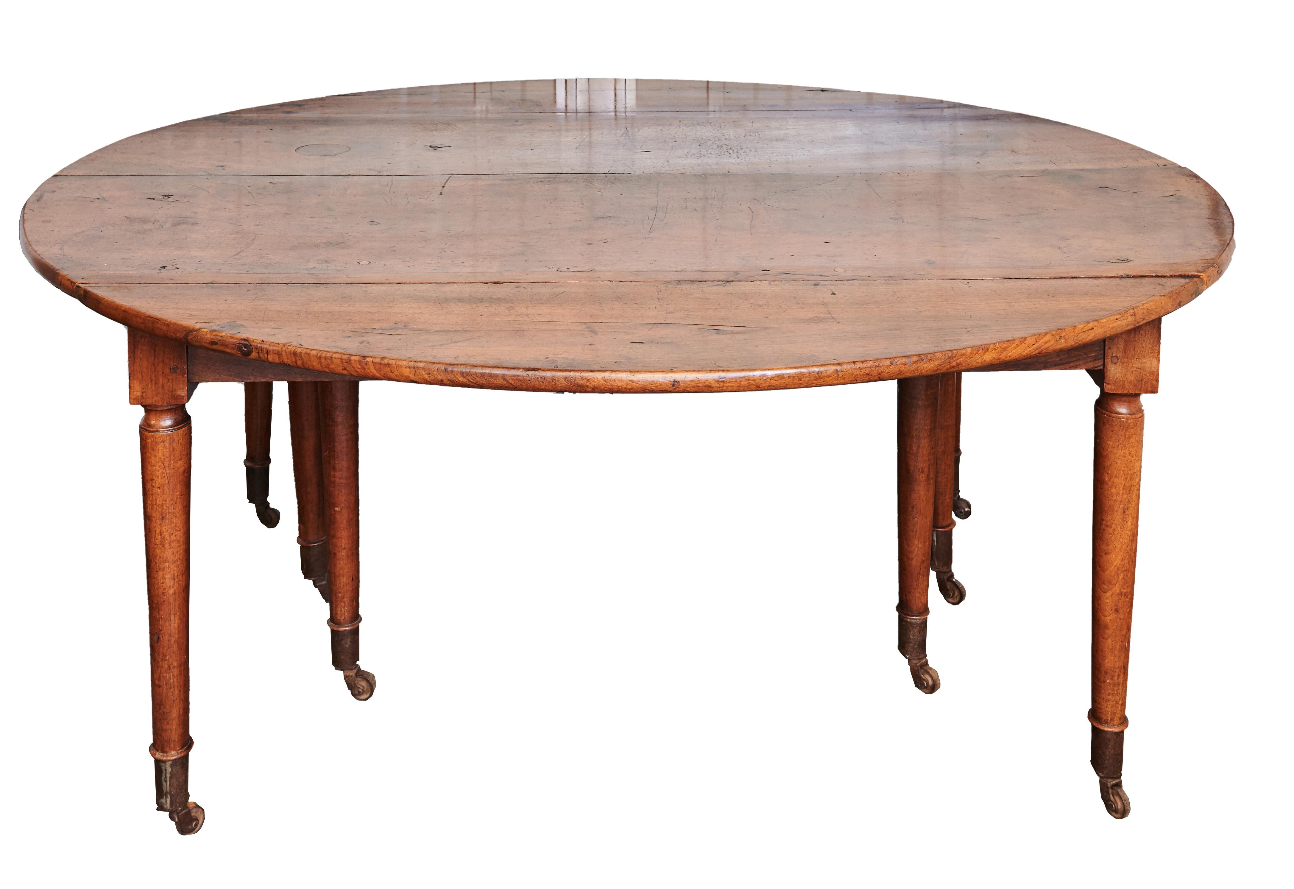 A solid walnut extending dining table, France, first half of the 19th century
With six additional leaves, the extending action incorporating five additional legs, on turned tapering legs, metal cappings and castors, 69 cm high, 166 cm wide, 130 cm