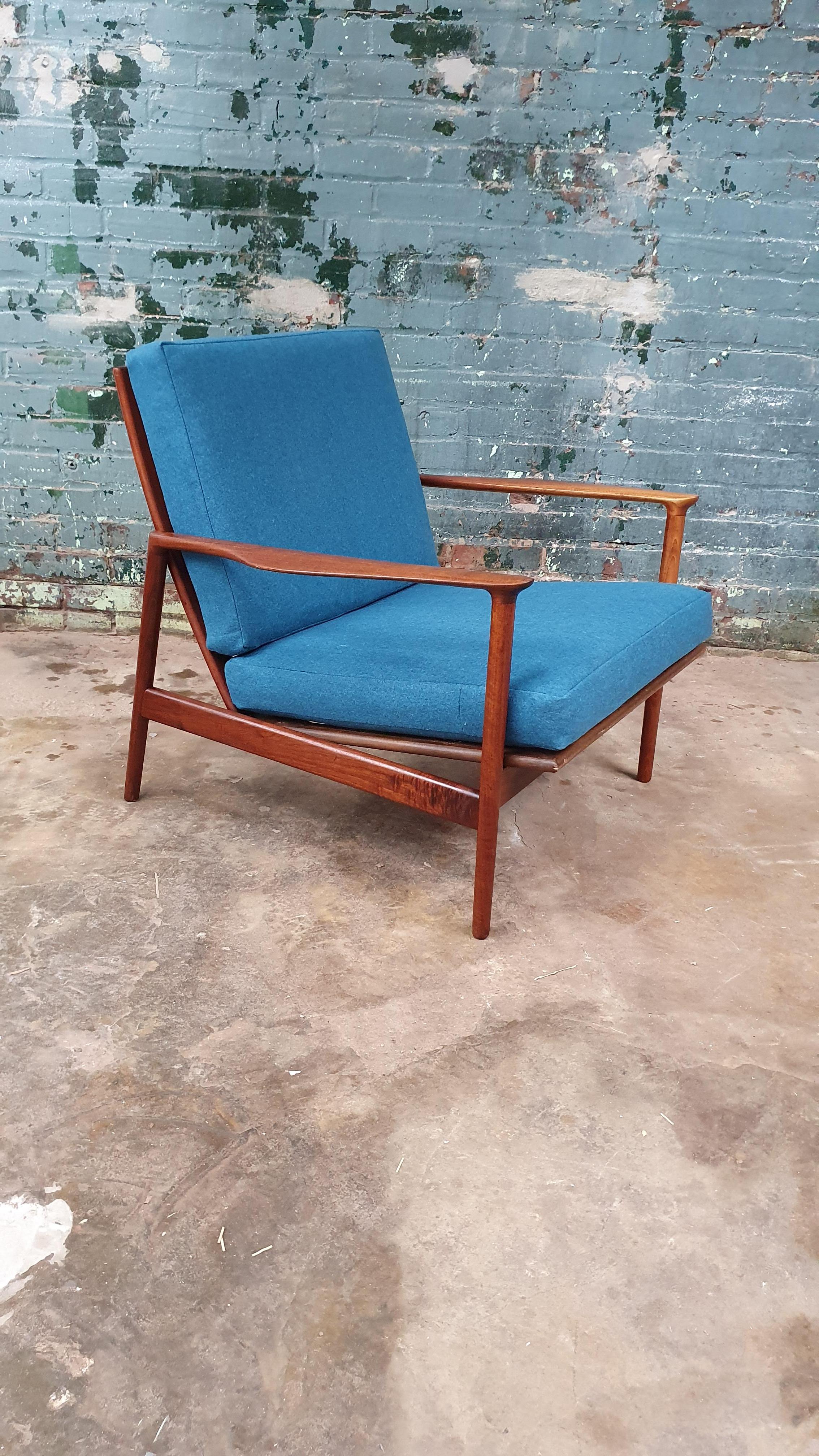 Beautiful solid walnut lounge chair by Ib Kofod-Larsen imported by Selig. features stunning sculpted arms new wool upholstery and new webbing with Evans clips Selig badge is present. the frame has been refinished.
