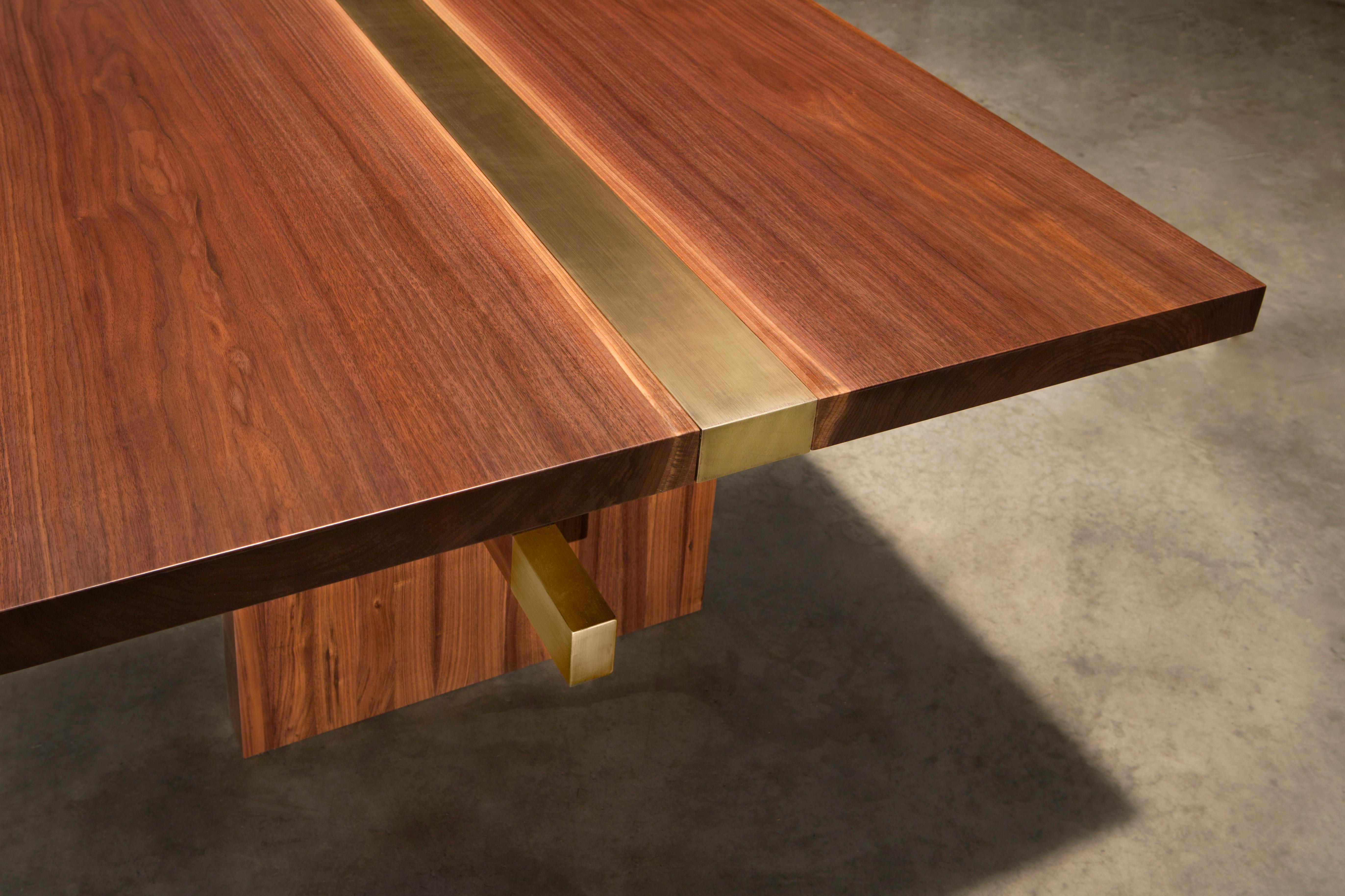 The Dequindre dining table uses two solid walnut slabs jointed to a brass metal insert to compliment the colors of each material. The solid walnut legs are also capped with brass as well to keep the style of the table constant throughout. 

This