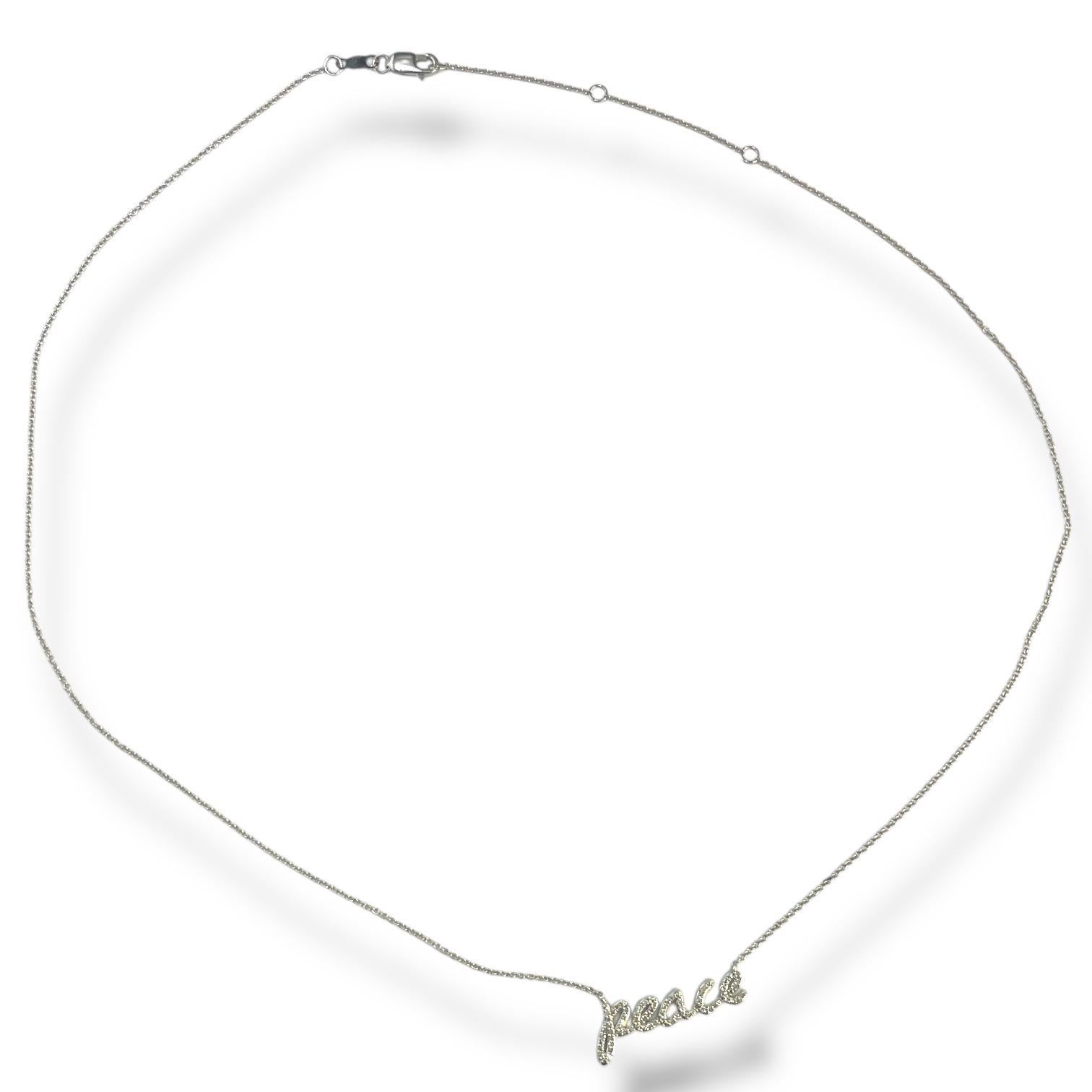 Eleva tu estilo con nuestro exquisito Collar Paz, elaborado en lujoso oro blanco de 14k y adornado con 0,16 ctw de brillantes diamantes. Esta elegante pieza presenta la palabra 