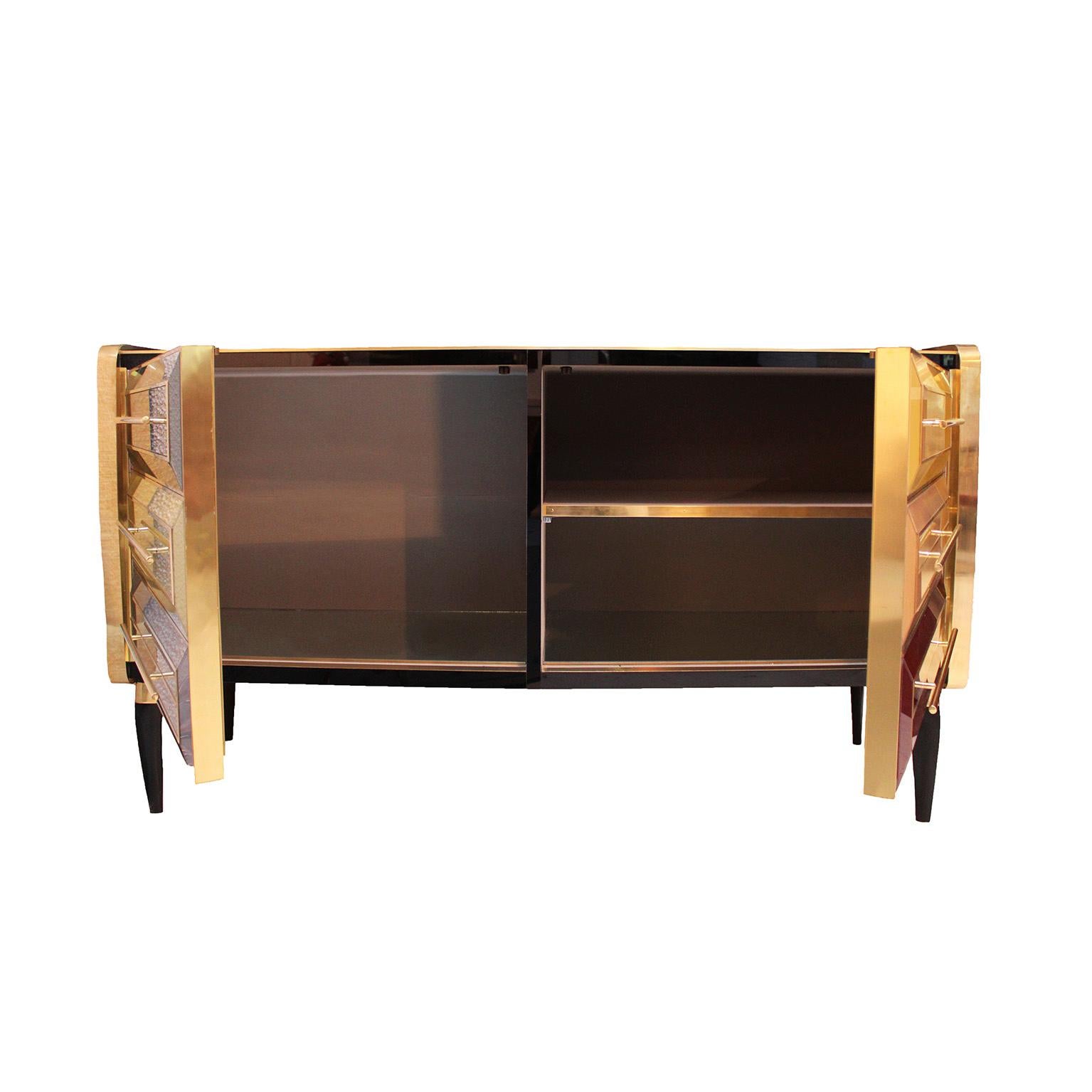 Bar cabinet consisting of 2 doors with an original structure from the 1950s made of solid wood and covered with colored glass. Sculptural legs made of solid wood. Handles and profiles made of brass.

Production time between 5 and 6