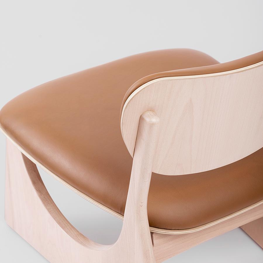 Crafted in solid beechwood with a Nordic white finish and camel-colored leather, the Tol Lounge Chair by Unicuo draws inspiration from the Mên-an-Tol, a prehistoric stone circle known as a portal between worlds. This sculptural lounge piece captures