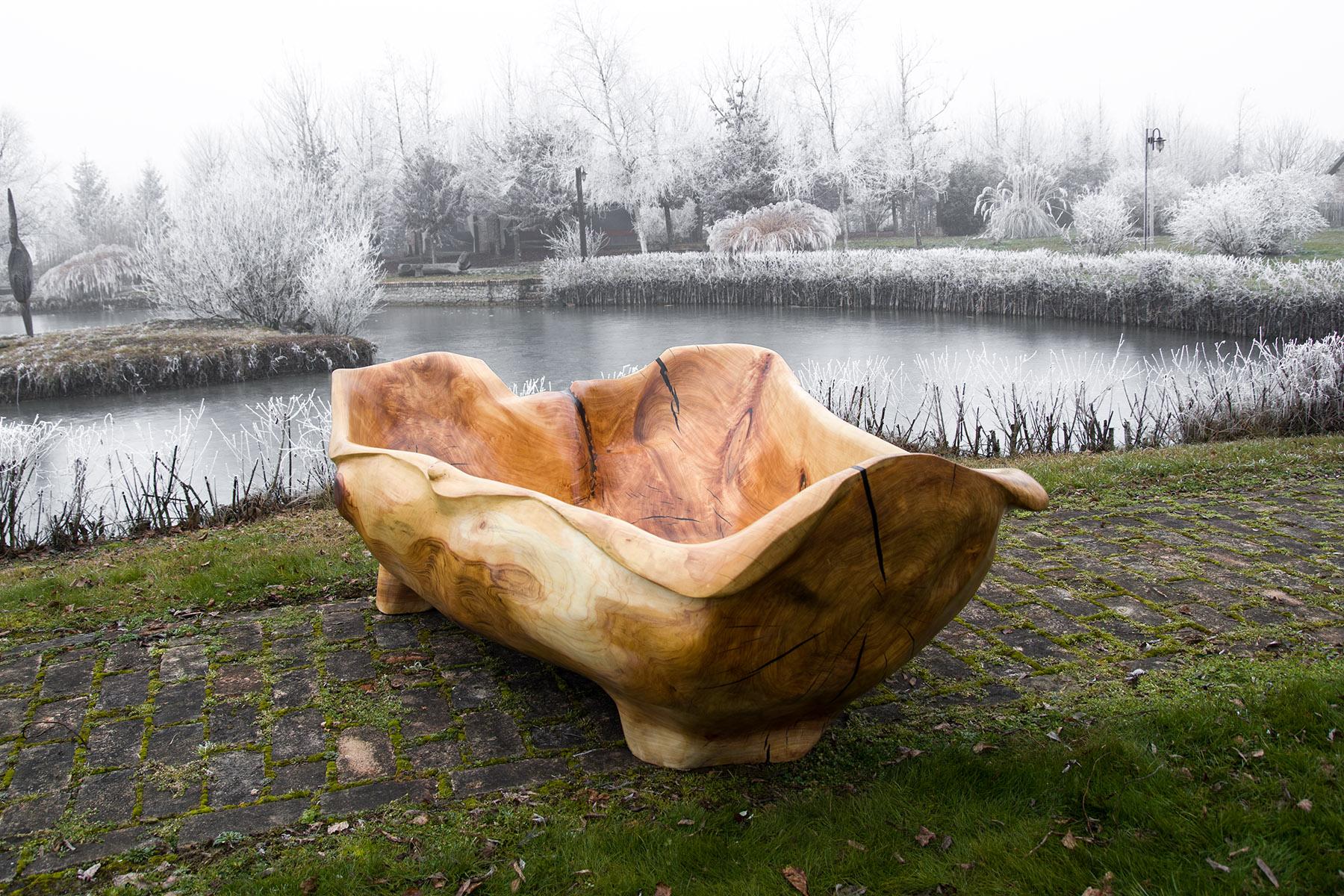 Unique functional sculpture carved from a single piece of wood in the shape of a bathtub. This magnificent two person bathtub is carved by artists with basic wood carving power tools with dedication to each detail. Decorating your interior with such