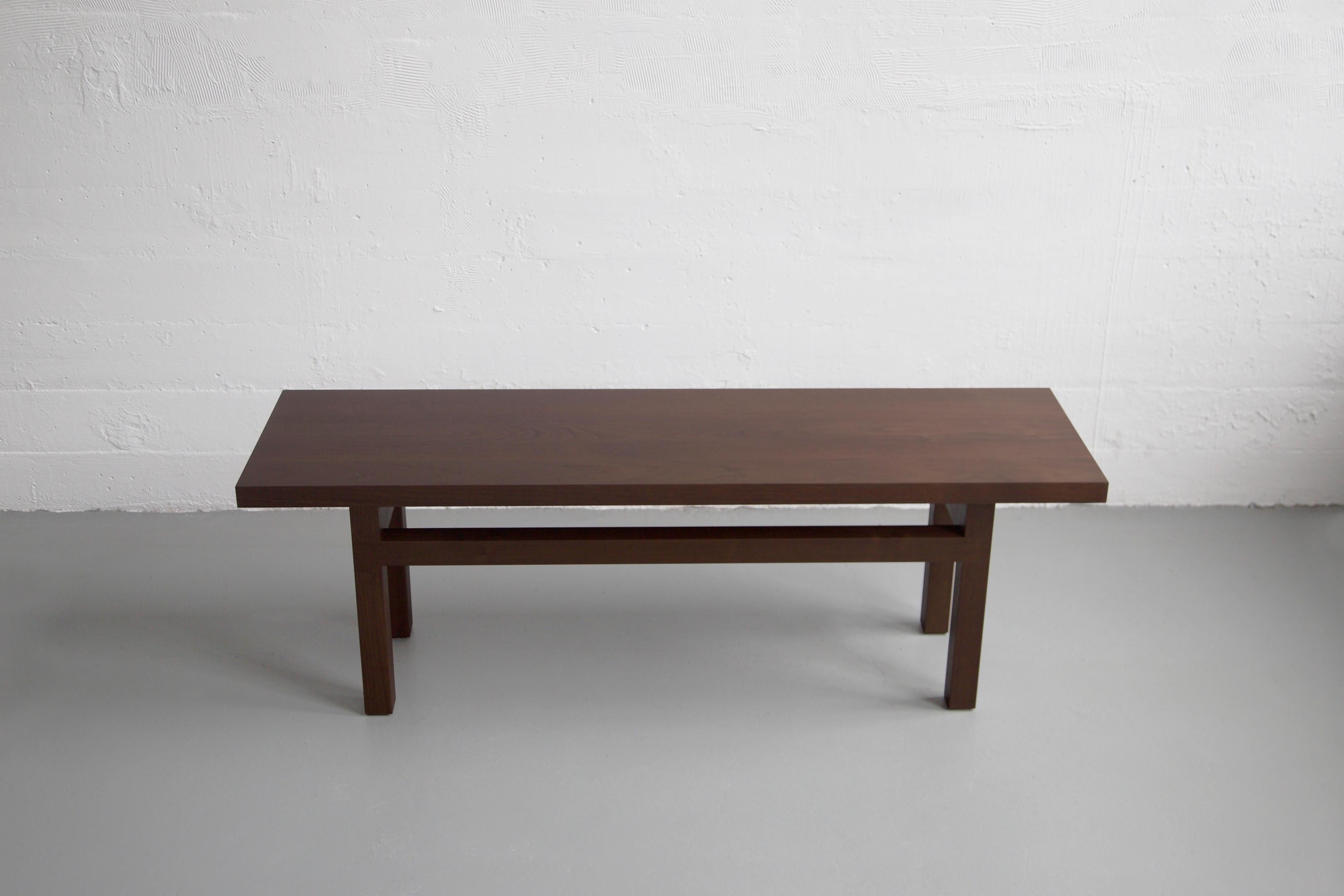 This contemporary bench is constructed of solid wood and made to order in our Brooklyn studio. Pictured in (darkened) walnut, the yarrow bench is accented with lap joint aprons and enlists group of slender timbers to visually elongate the