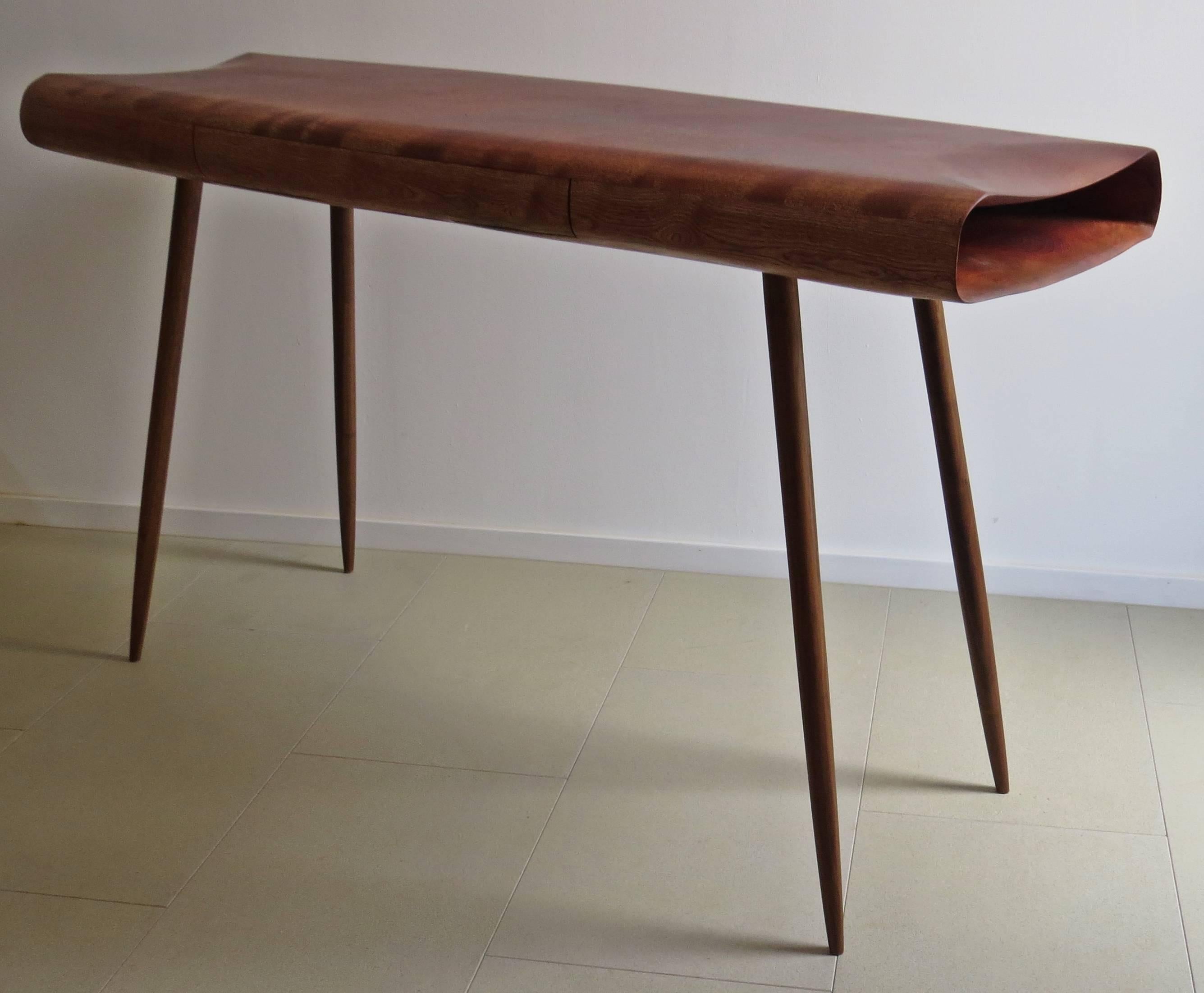 Schreibtisch oder Konsole aus Massivholz in organischem Design.
Hergestellt vom deutschen Tischler und Bildhauer Eckehard Weimann.
Die Möbel sind handgefertigt. Der Körper wird organisch bearbeitet, Falten und Kurven werden fein geschliffen. Diese