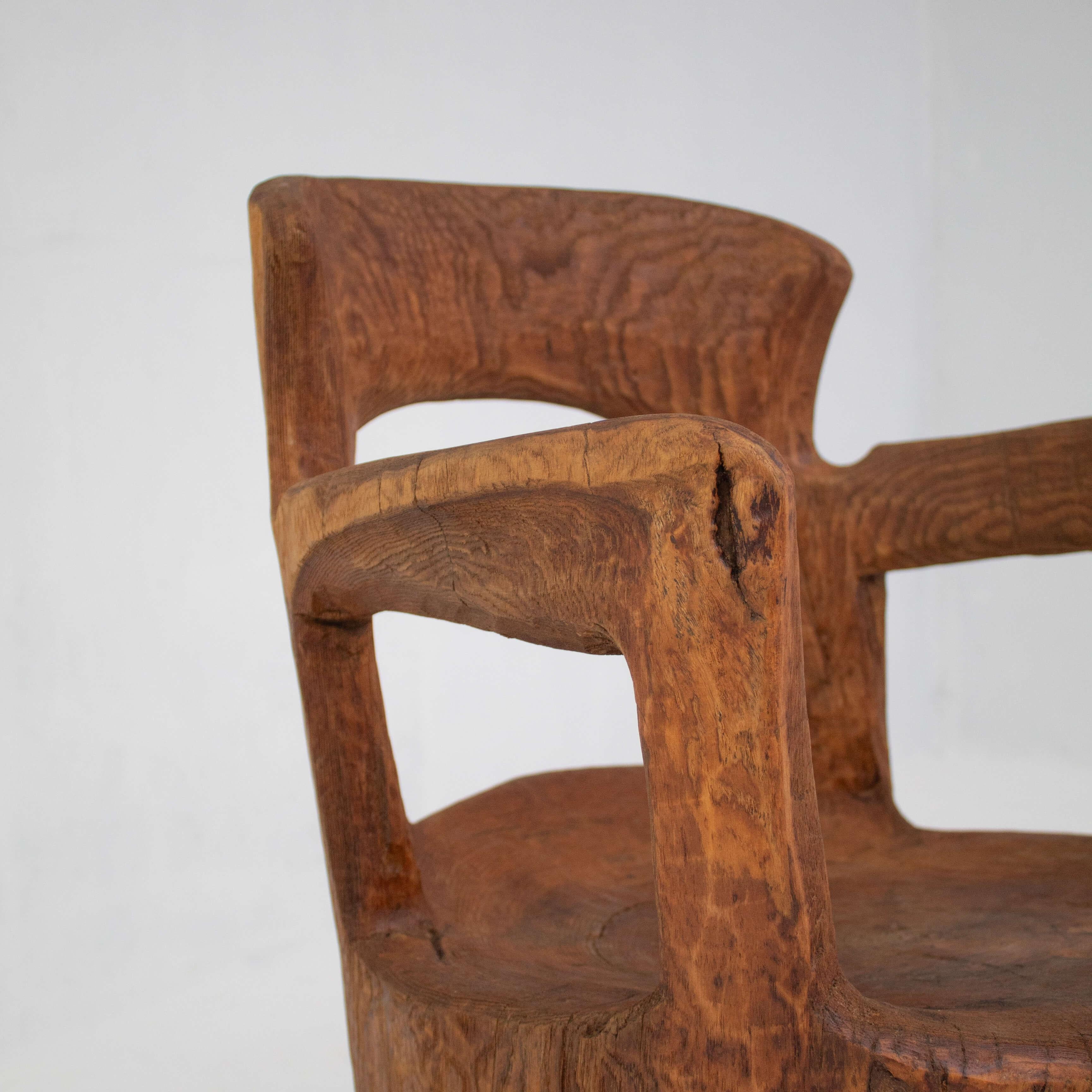 Cette étonnante chaise en bois massif sculptée à la main illustre la beauté du bois naturel et de l'artisanat qualifié. Avec son design sculptural, la chaise présente des courbes douces et fluides ainsi que des découpes uniques qui en font une pièce