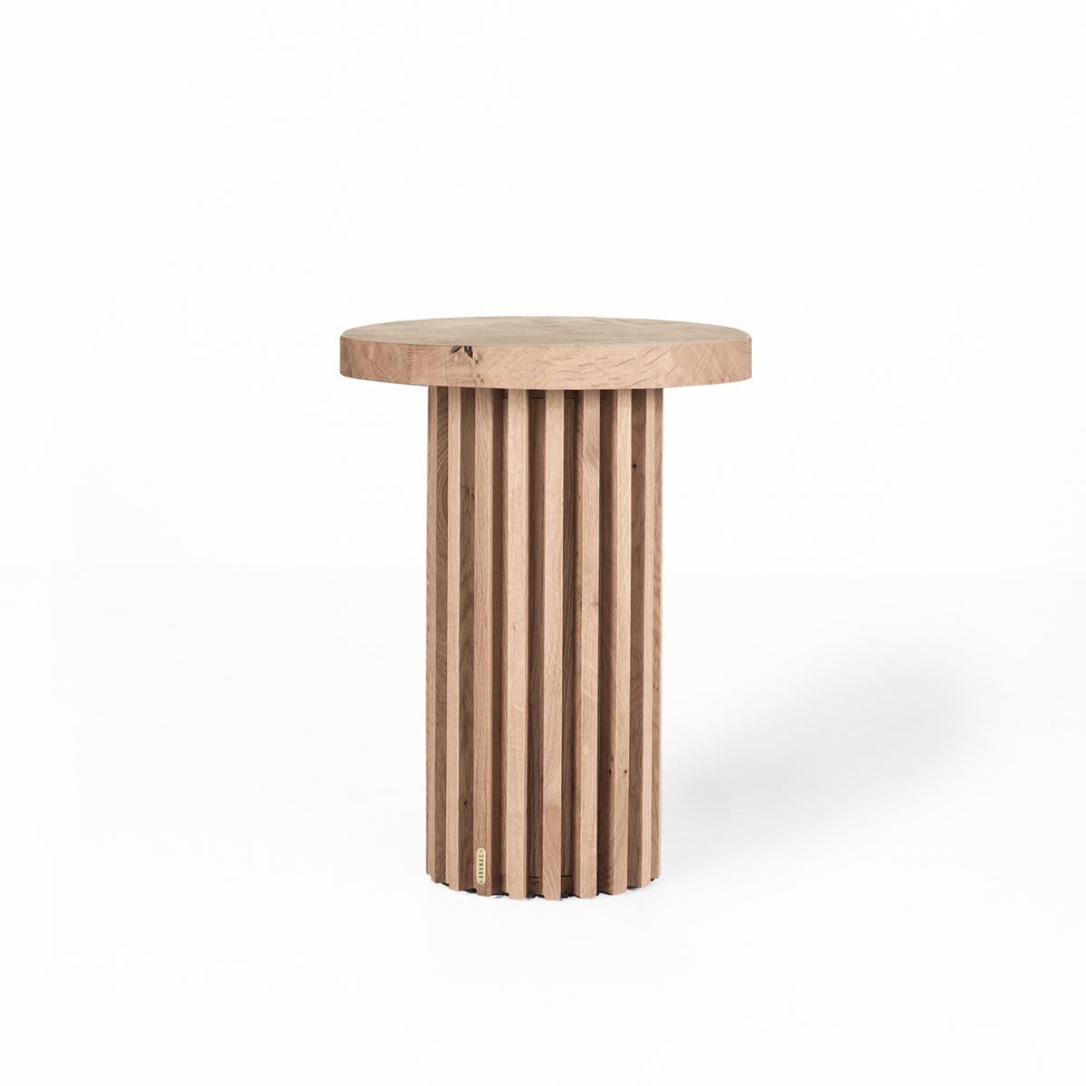 La table basse/côté ronde à lattes en chêne massif DOCIA est conçue pour apporter à la fois élégance et fonctionnalité à votre espace de vie. Fabriquée à la main en bois de chêne naturel, cette pièce unique se distingue par sa structure légère et sa
