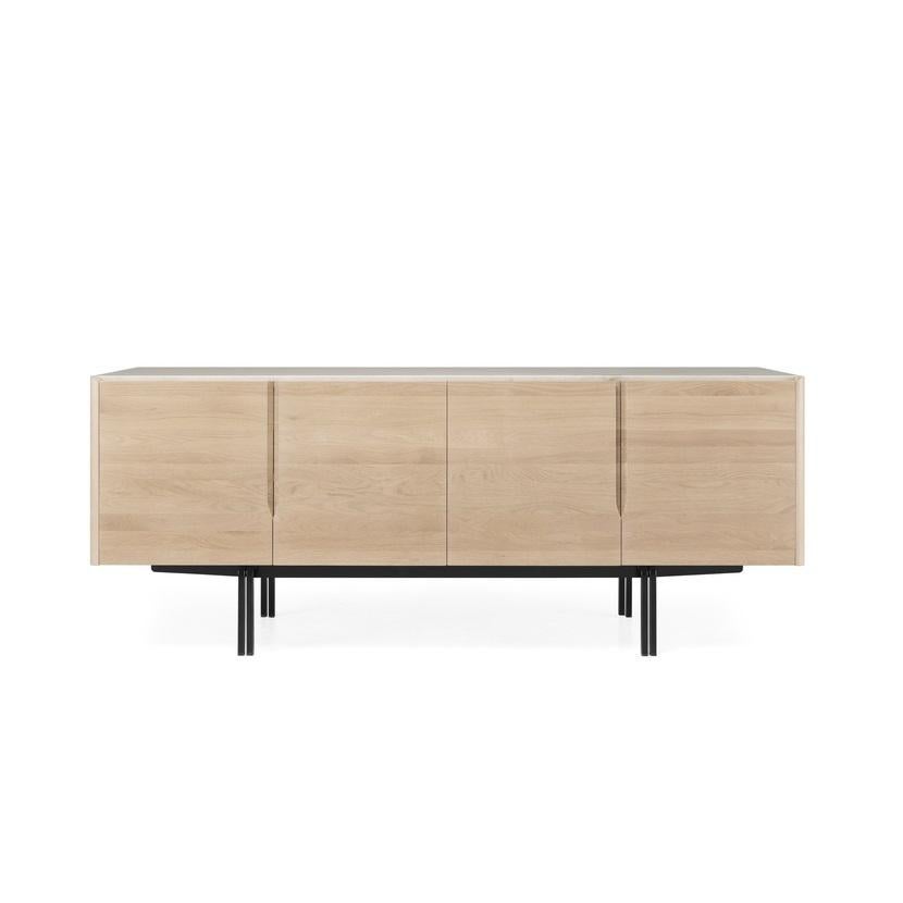 Ce buffet mêle des matériaux luxueux comme le bois noble et le marbre. Ses pieds en fer tubulaire, en forme de 