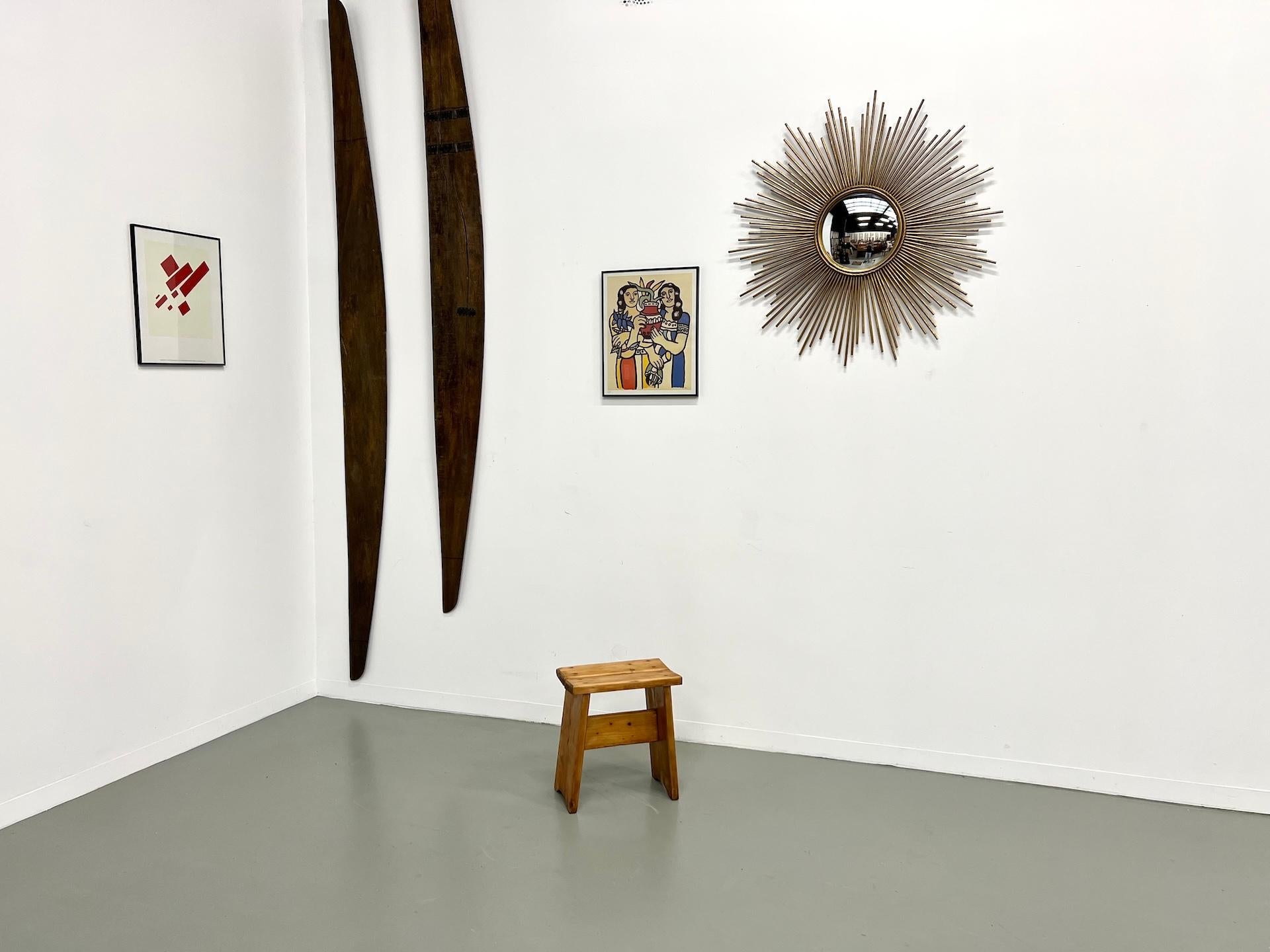 Maison Lecan presents this rustic solid wood stool, crafted in the 1950s-70s, in the style of Charlotte Perriand.

Its seat, made of two thick planks fixed with visible bolts, rests on slightly splayed trapezoidal legs — a design that reflects the