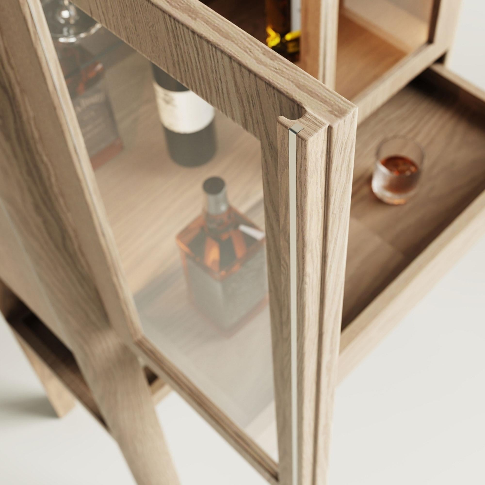The minimalist solid-oak wine cabinet with chrome accents—measuring 80 × 43 × 165 cm—is the perfect showcase for your liquor and wine collection. When you open the drawer of this LED-lit cocktail cabinet, a built-in prep surface slides out, making