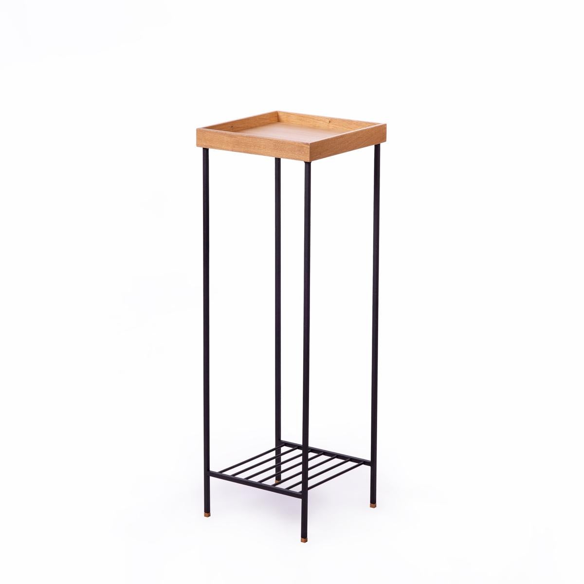 Der Beistelltisch der Serie EDGE aus massiver Eiche mit Metalllamellen ist ein raffiniertes Beispiel für die Kunst der Holzbearbeitung. Dieser hohe Beistelltisch kombiniert eine Platte aus massivem Eichenholz mit Metallbeinen im Industriestil und