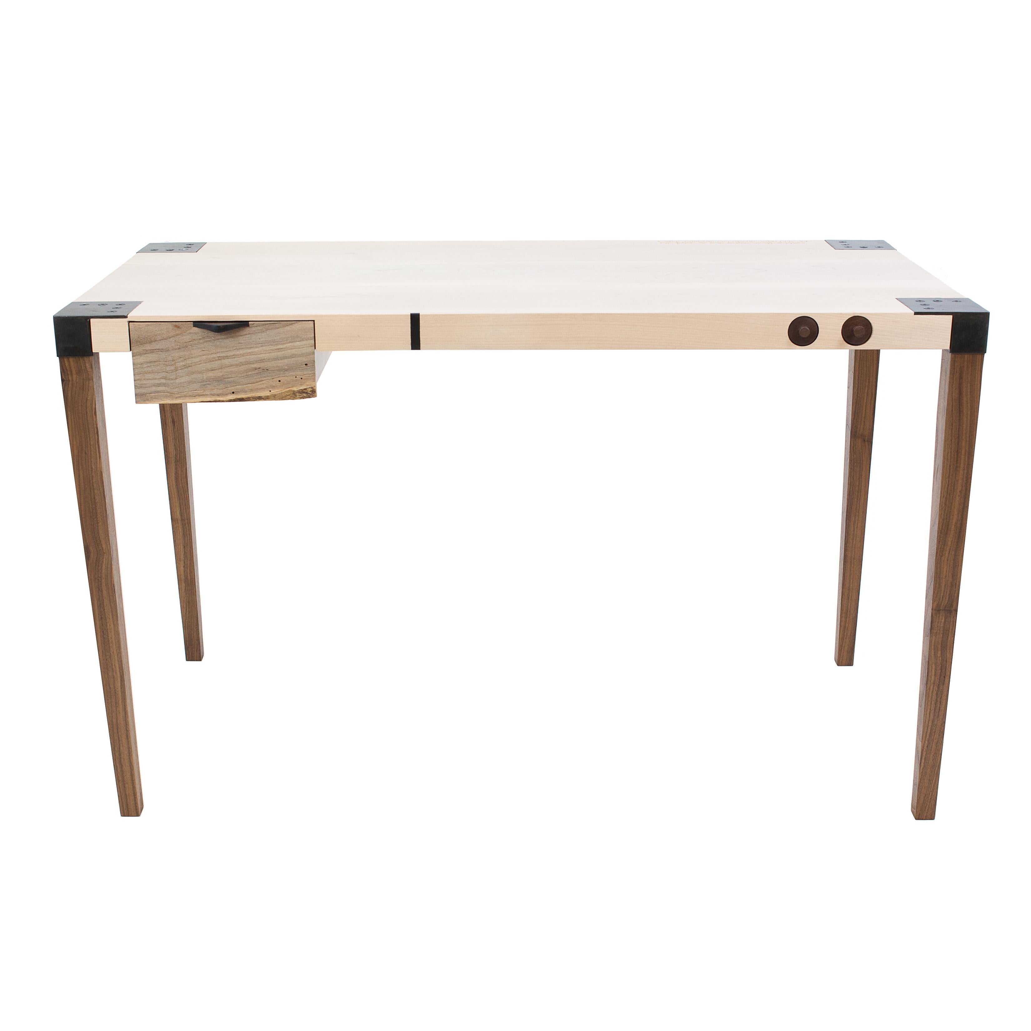 This writer's desk is an exercise in restraint. This sleek desk’s tapered legs are made from solid Walnut and are detachable thanks to the custom blackened steel joinery. The solid wood top of this fully customizable piece features inlays and/or