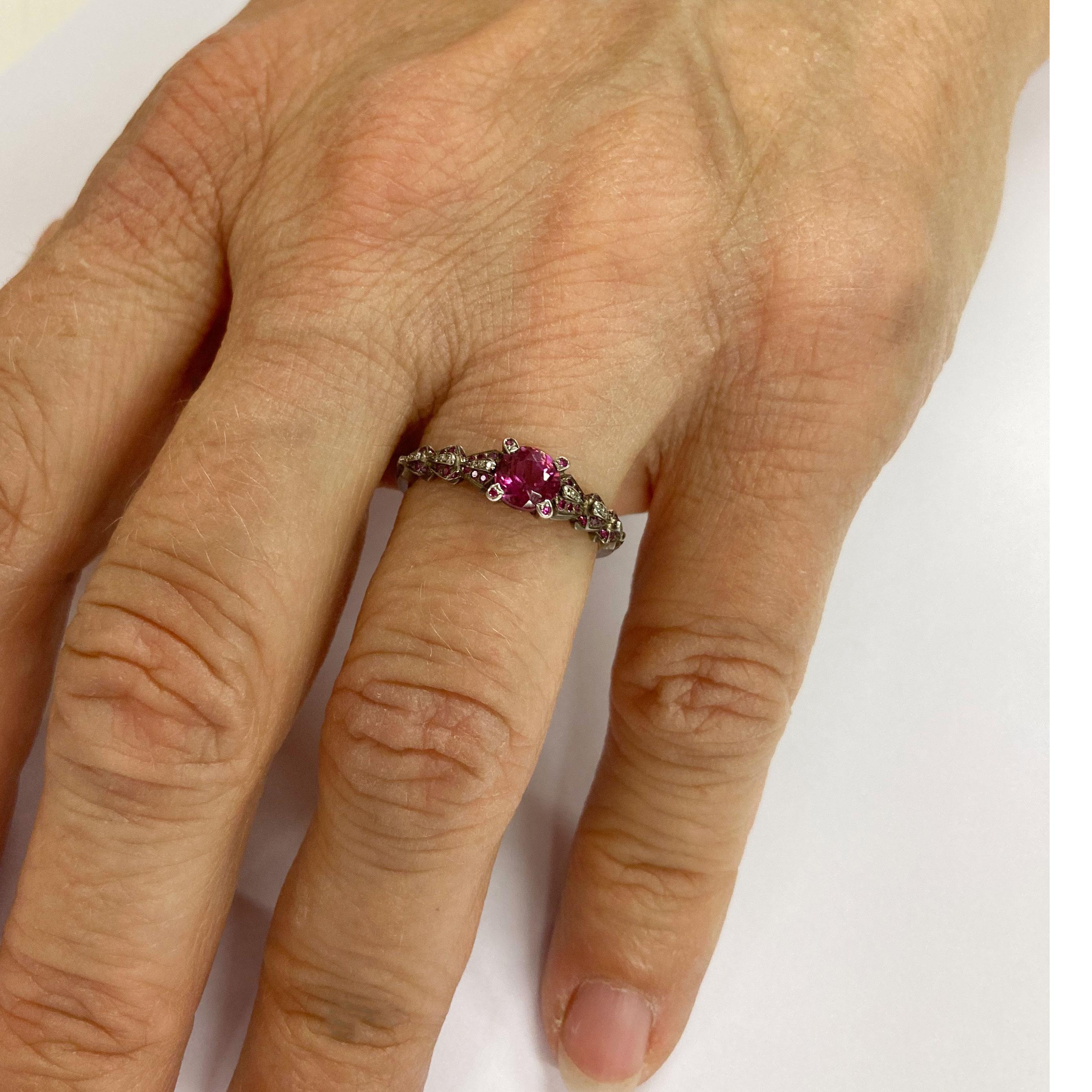 This extraordinary Ring in 18 Kt White Gold showcases a Pink Tourmaline ,Rubelith of 0.65 ct in a 4 prong setting . The shoulders have an organic appearance and are pave set with 42 Pink Sapphires with a total weight of 0.08 ct and 24 Diamonds with