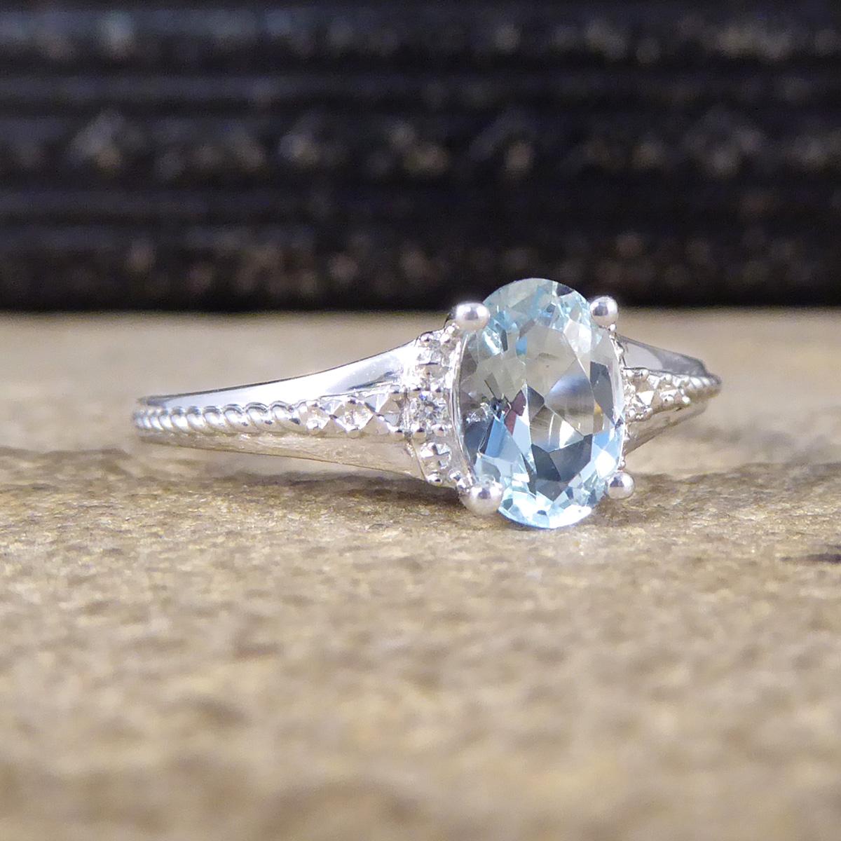 Featuring in this new ring is a light blue single Aquamarine in a four claw setting. There is one small Diamond set into the shoulders of this ring on either side of the Aquamarine. The Diamond are set into a grained illusion setting giving the