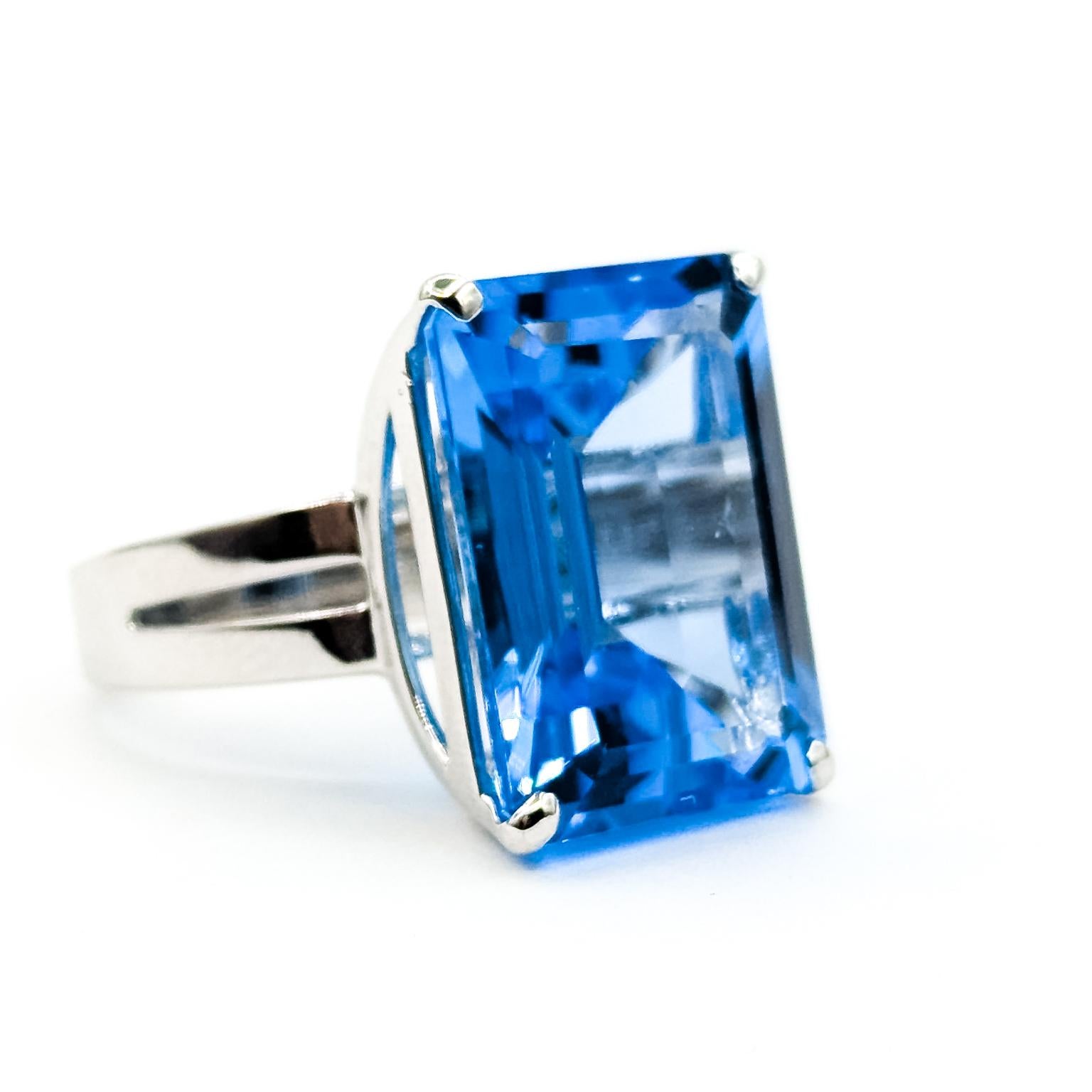 Solitär Blauer Topas Ring in 14k Weißgold

Dieser Ring ist aus 14-karätigem Weißgold gefertigt und zeigt einen auffälligen Blautopas von 25,87 Karat in einem klassischen Solitär in Zackenfassung. Der Topas im Smaragdschliff zeigt eine brillante