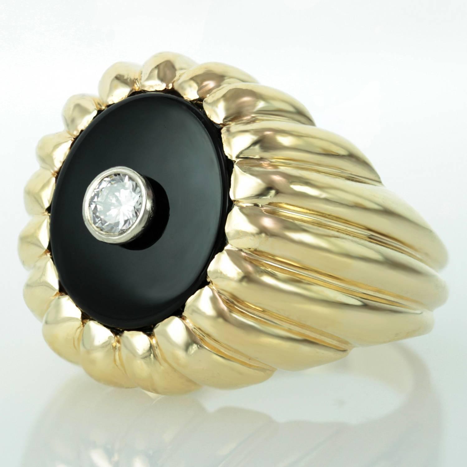 This stunning vintage men's ring is made in 14k yellow gold and features a circular black Onyx crown bezel-set with a sparkling solitaire diamond, estimated 0.20 carat. 
Circa 1980s. Measurements: 0.74
