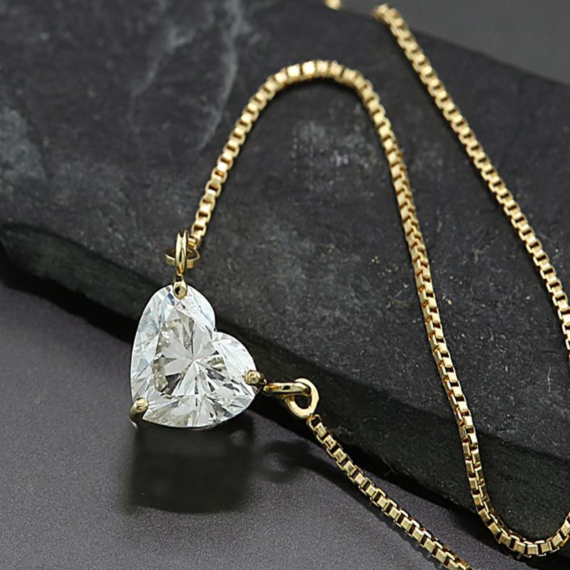 un collier avec un diamant en forme de cœur d'un demi-carat. Couleur : J, Clarté : VS.  Il est serti d'une manière particulière avec trois griffes qui permettent de voir le diamant en forme de cœur de côté. Le collier est composé d'une chaîne
