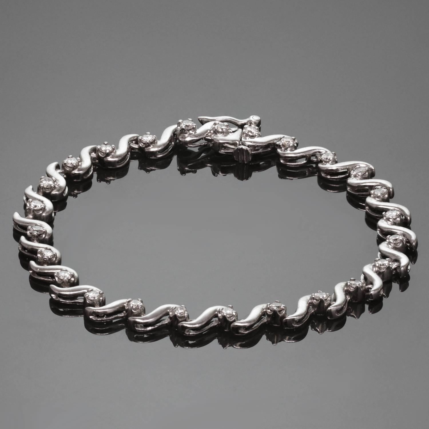 Ce bracelet de tennis classique et moderne présente des maillons ondulés en or blanc 14k sertis de 24 diamants ronds solitaires d'une valeur estimée à 1,10 carats. Un design intemporel pour une élégance de tous les jours. Dimensions : 0,19