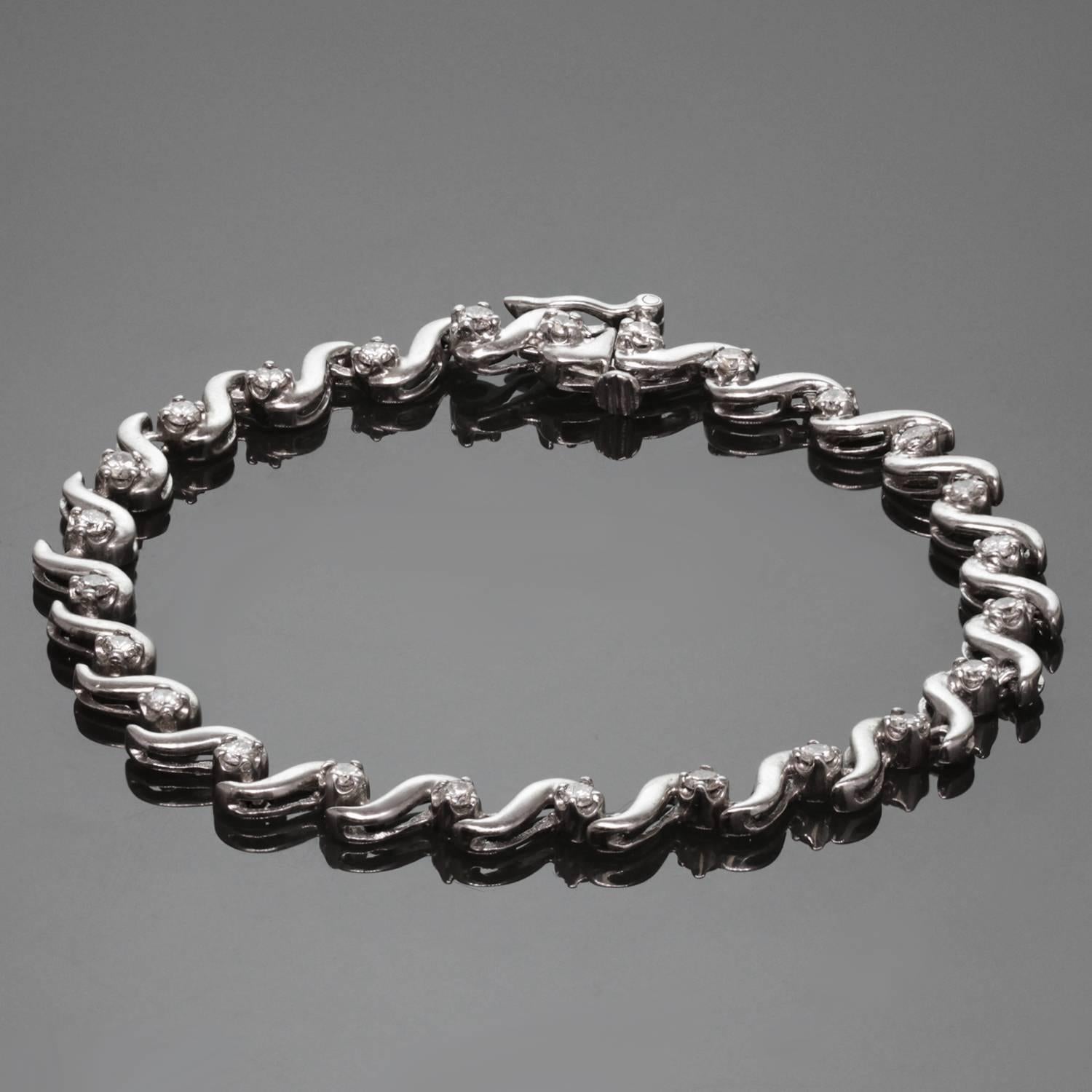 Ce bracelet de tennis classique et moderne présente des maillons ondulés en or blanc 14k sertis de 24 diamants ronds solitaires d'une valeur estimée à 1,40 carat. Un design intemporel pour une élégance de tous les jours. Dimensions : 0,19