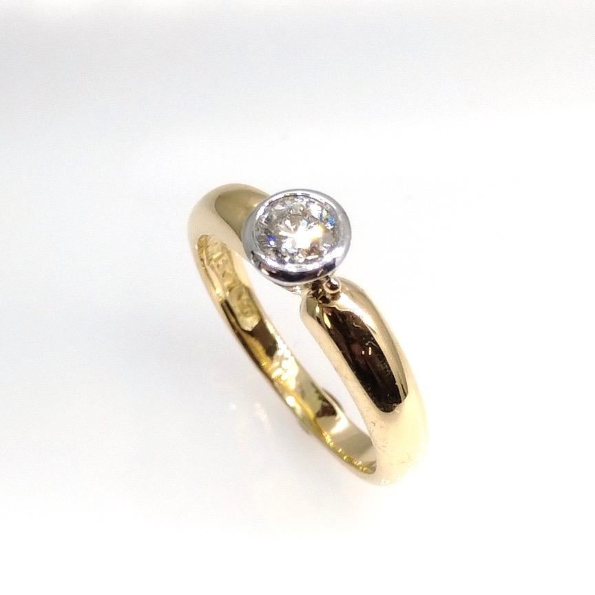 Hand made 18 carat yellow gold ring 
with one brilliant cut Diamond rub-over set in white 18 carat gold.
Diamond weight is 0.41 carats, Colour H, Clarity VS.
Ring size is L 1/2 (Us size is 6)
Weight of the ring is 4.8 grams