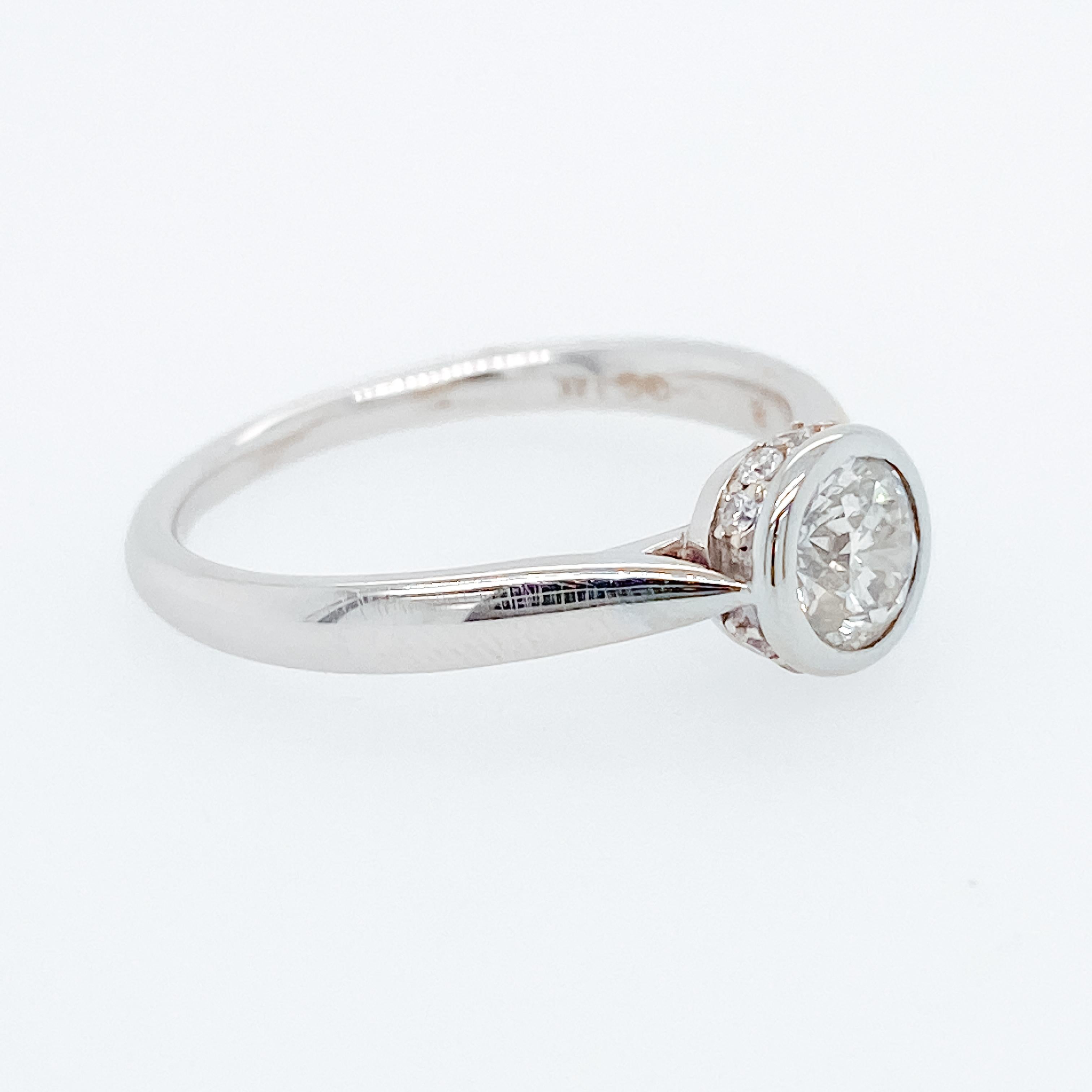 This gorgeous diamond engagement ring has a round brilliant cut diamond set in a glorious bezel w a hidden halo of diamond below. Everything about this ring is elegant and our jeweler that made it wanted it to be one that you could wear with